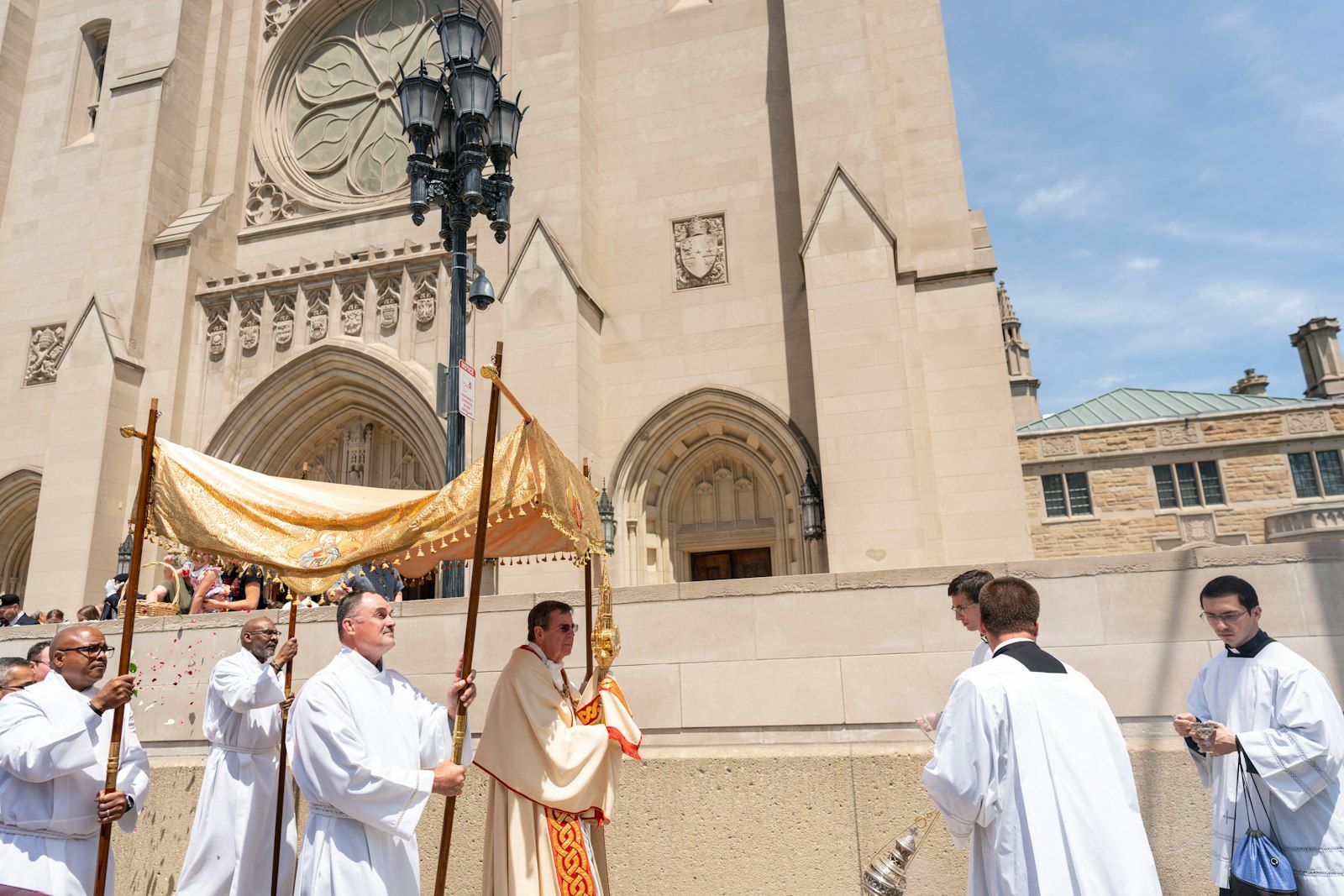 People throw flower petals from the porch of the Cathedral of the Most Blessed Sacrament in Detroit as Archbishop Allen H. Vigneron carries the Eucharist in procession during the solemnity of Corpus Christi, June 19, 2022. (Melanie Reyes | Special to Detroit Catholic)