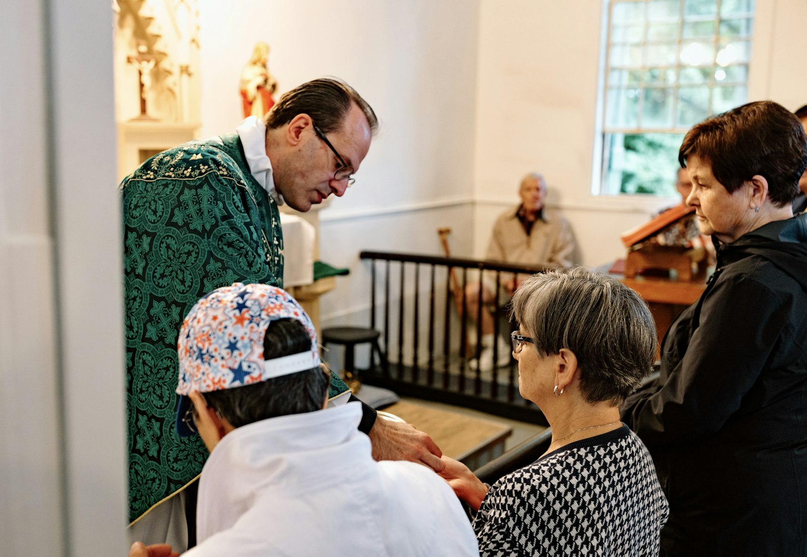 Fr. David Cybulski, moderator and priest in solidum at St. Patrick, distributes Communion during Mass inside the historic chapel May 27.