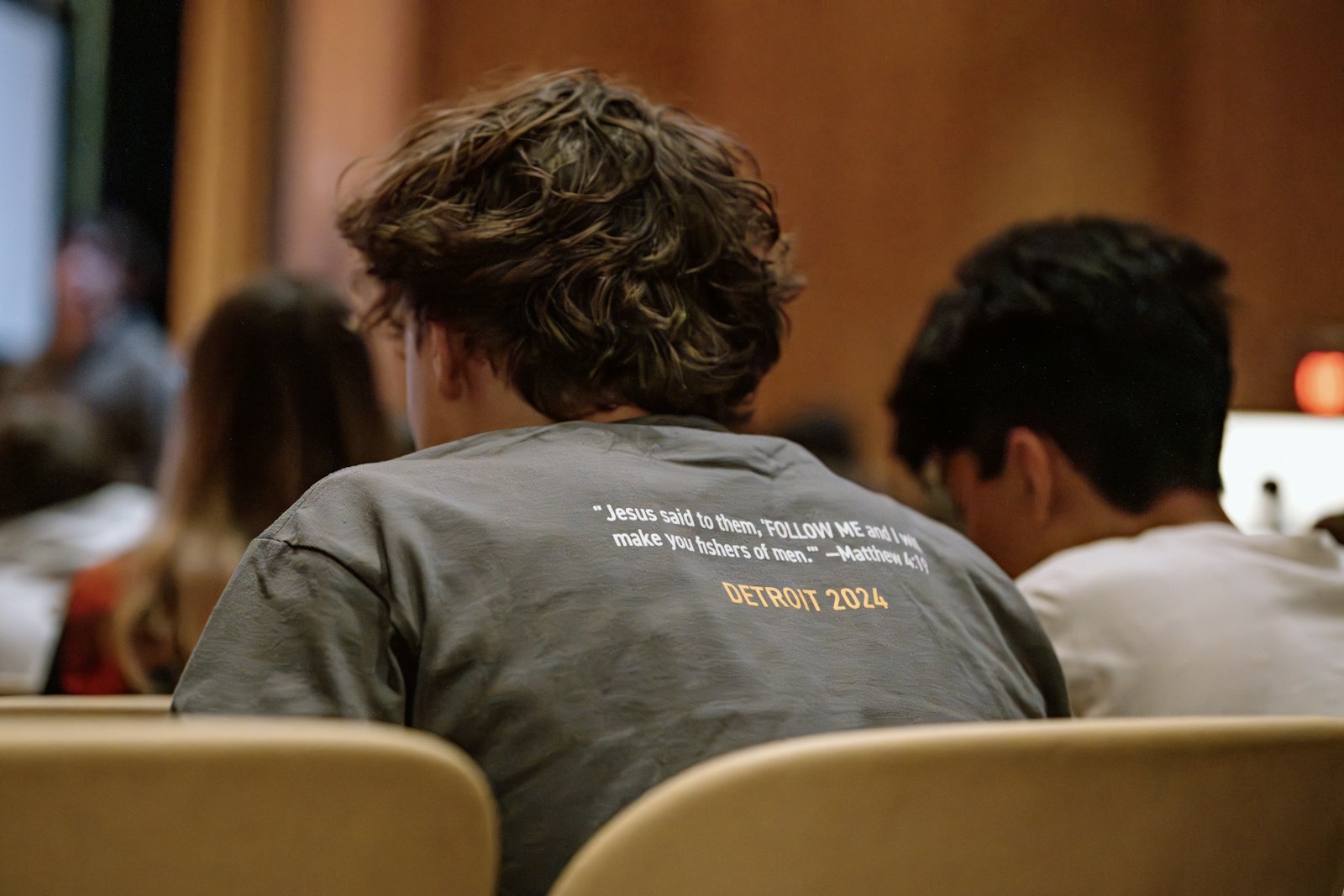 A teen's shirt proclaims a powerful Scripture passage as he listens to the keynote speaker during RISE 2024 at Mercy High School. (Alissa Tuttle | Special to Detroit Catholic)
