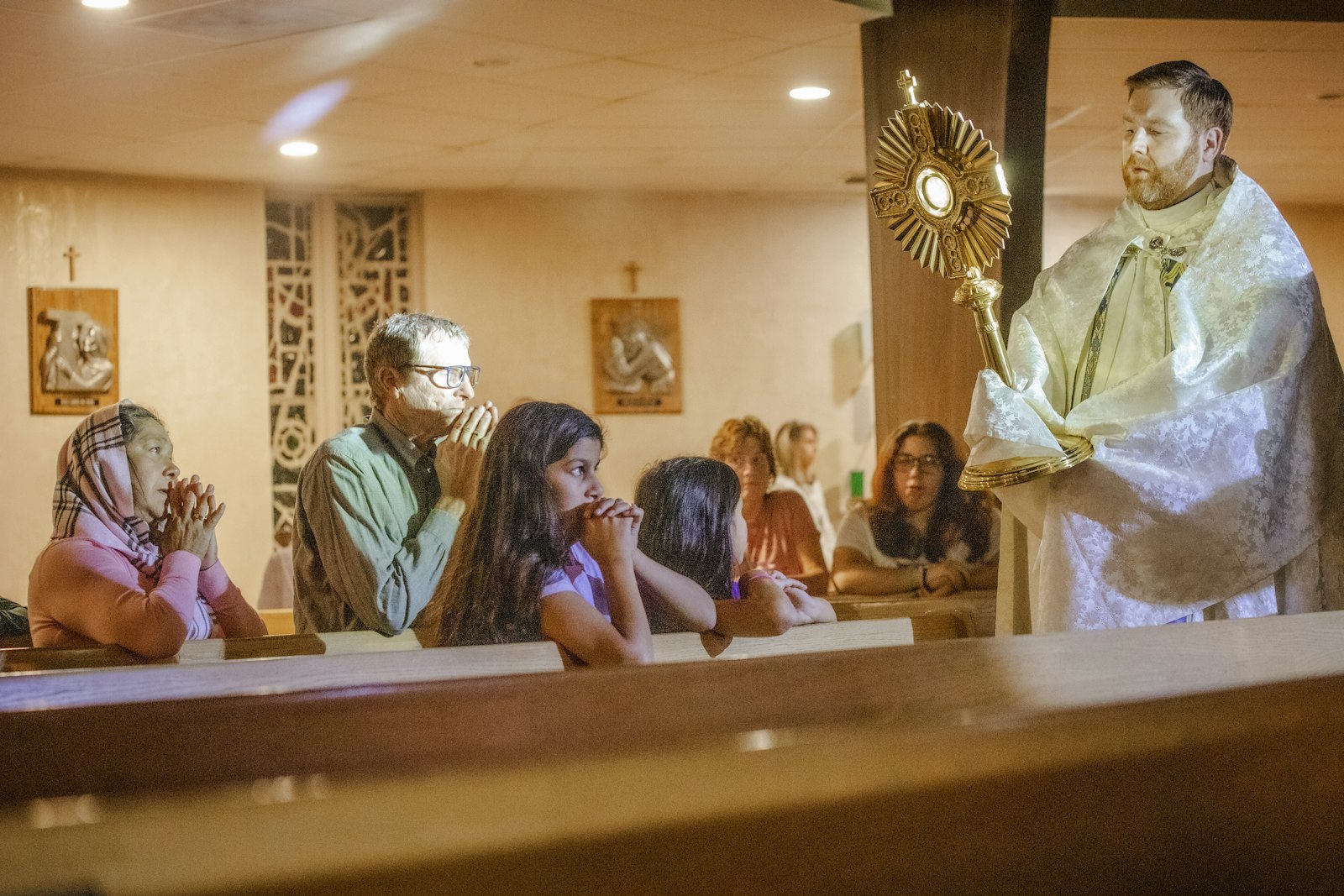 Padre Stephen Pullis sostiene una custodia donde lleva al Santísimo Sacramento bendiciendo a adolescentes y adultos reunidos en la parroquia de St. Ronald en el municipio de Clinton como parte de un evento especial "Ven, encuentra a Cristo" el 23 de octubre. (Alissa Tuttle | Especial para Detroit Catholic)