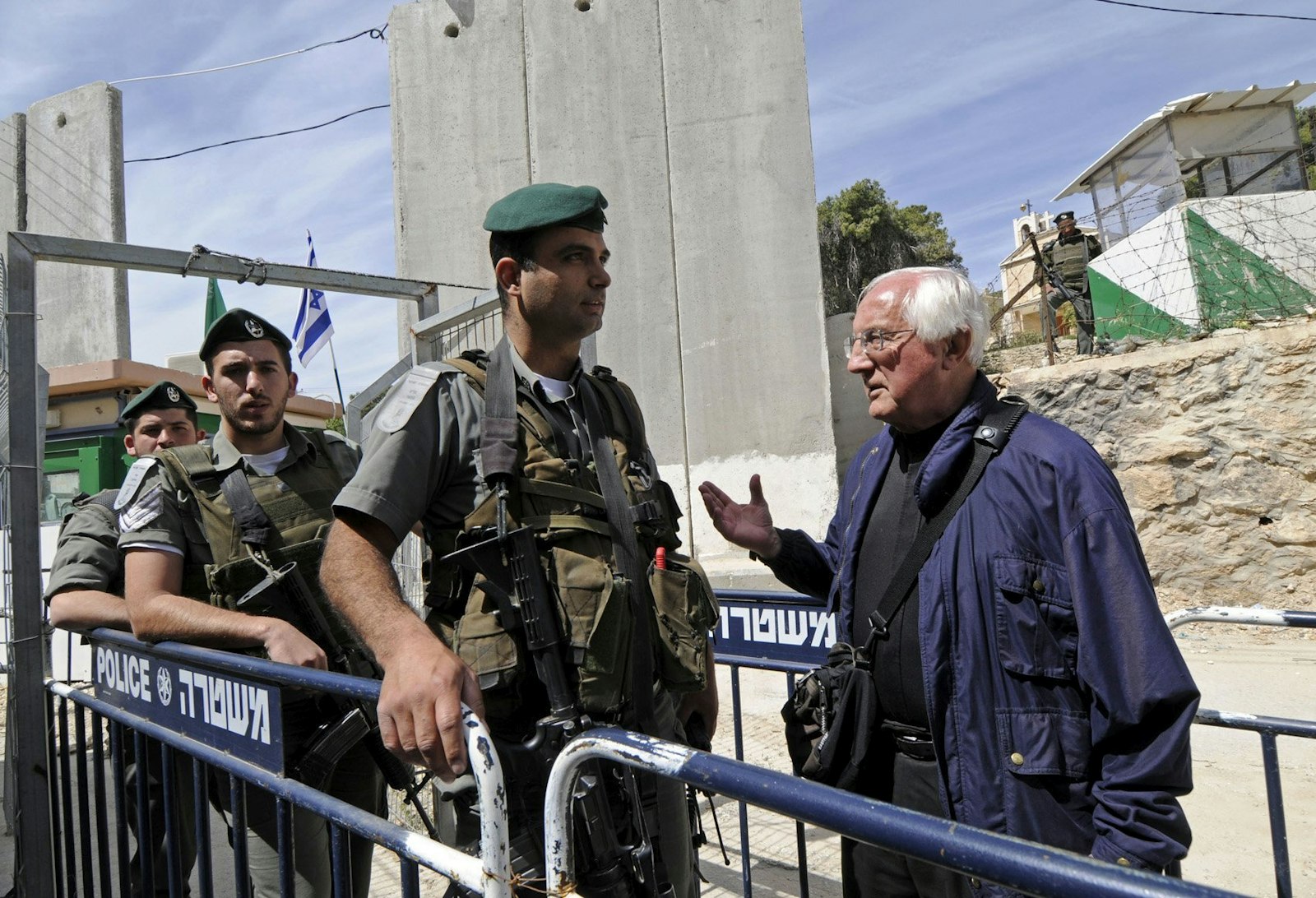 Bishop Gumbleton tries to persuade Israeli border police to let Palestinians and international visitors pass through the gate to Jerusalem during a Palm Sunday procession from Lazarus' Tomb in Bethany to the Bethany Gate at the Israeli separation wall in the West Bank on March 16, 2008. (Debbie Hill | CNS photo)