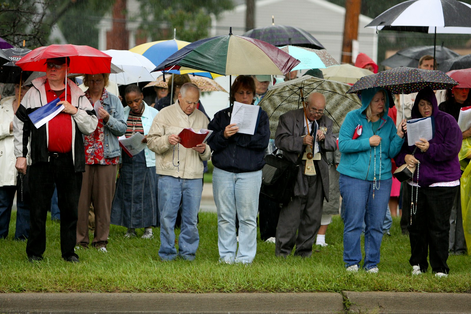 Volunteers pray the rosary in the rain outside an abortion clinic on 8 Mile Road in 2011. In addition to a regular presence of prayer and support outside abortion clinics, Helpers of God's Precious Infants frequently organizes rosary processions and prayer vigils. (Photo by Dianne Korzeniewski, courtesy of Helpers of God's Precious Infants)