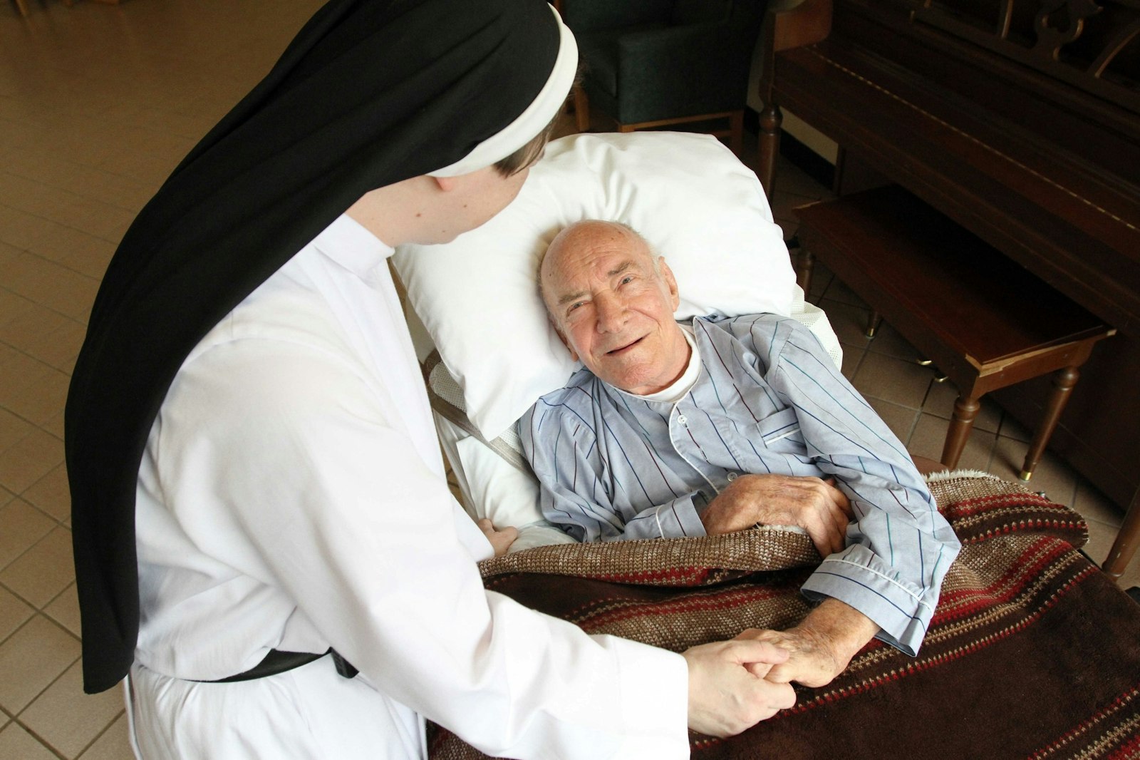 A patient is pictured in a file photo chatting with a nun at Rosary Hill Home, a Dominican-run facility in Hawthorne, N.Y., that provides palliative care to people with incurable cancer and have financial need. (CNS photo/Gregory A. Shemitz)