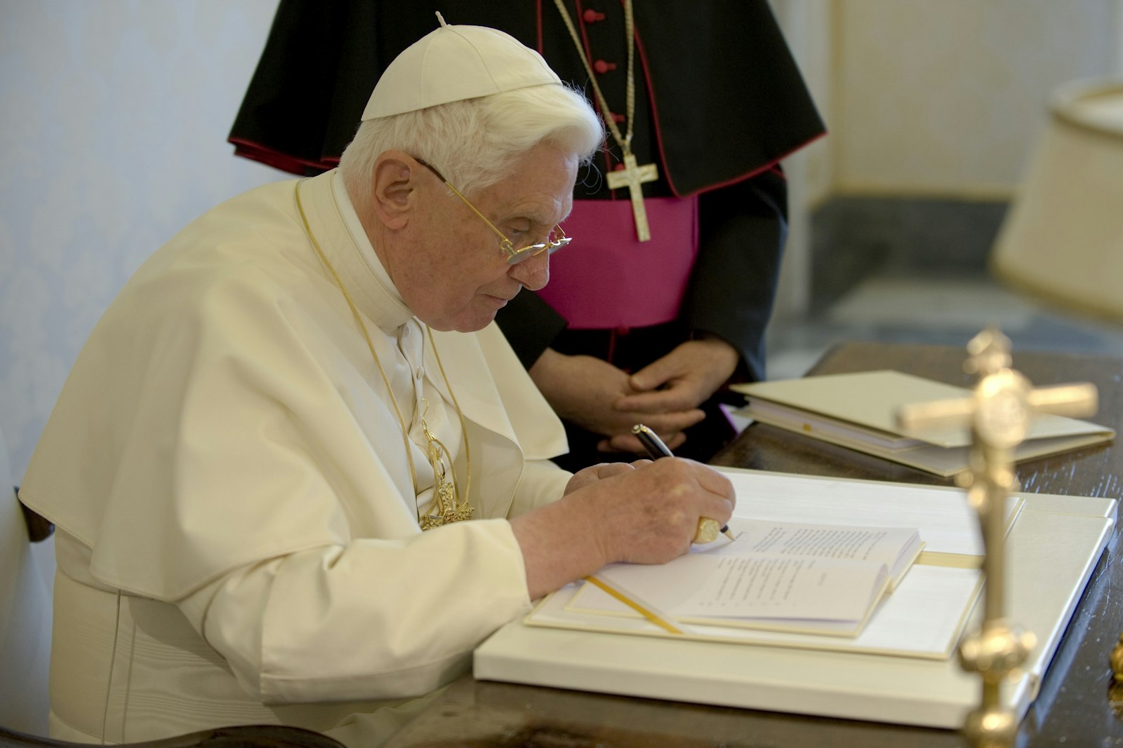 Pope Benedict XVI signs a copy of his encyclical, "Caritas in Veritate" ("Charity in Truth"), at the Vatican July 6, 2009. (CNS photo/L'Osservatore Romano via Catholic Press Photo)