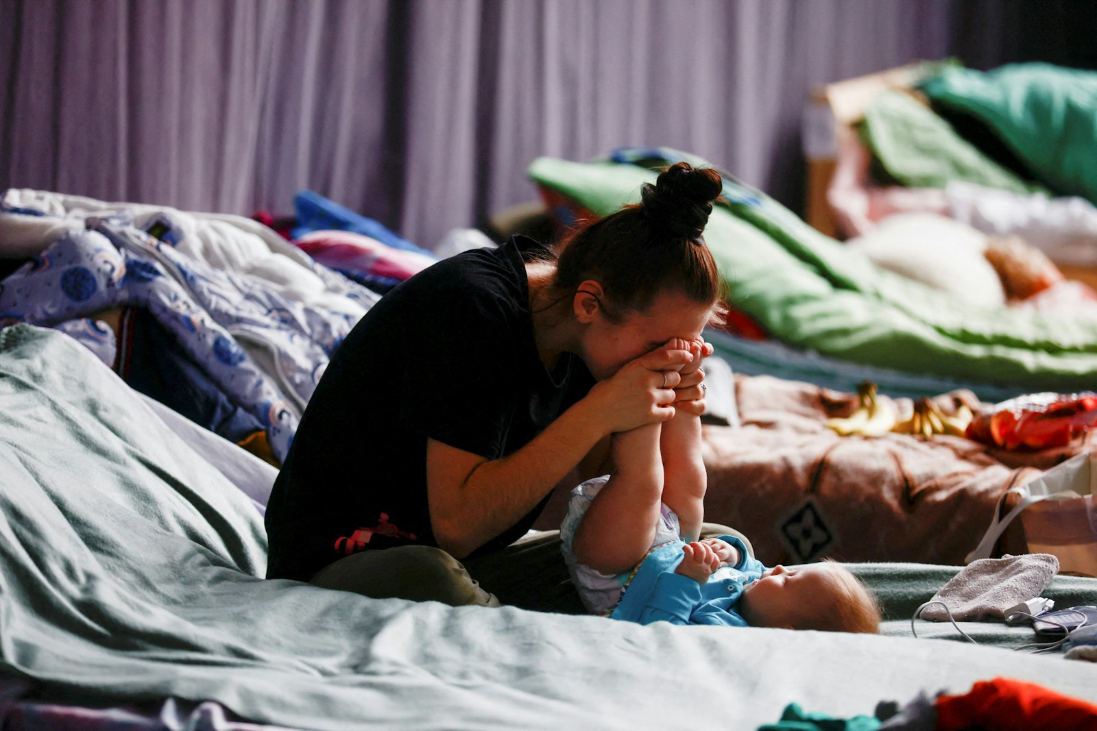 A woman in Przemysl, Poland, plays with her child March 9, 2022, in a sports hall of a high school transformed into temporary accommodations for people fleeing the Russian invasion of Ukraine. (CNS photo/Yara Nardi, Reuters)