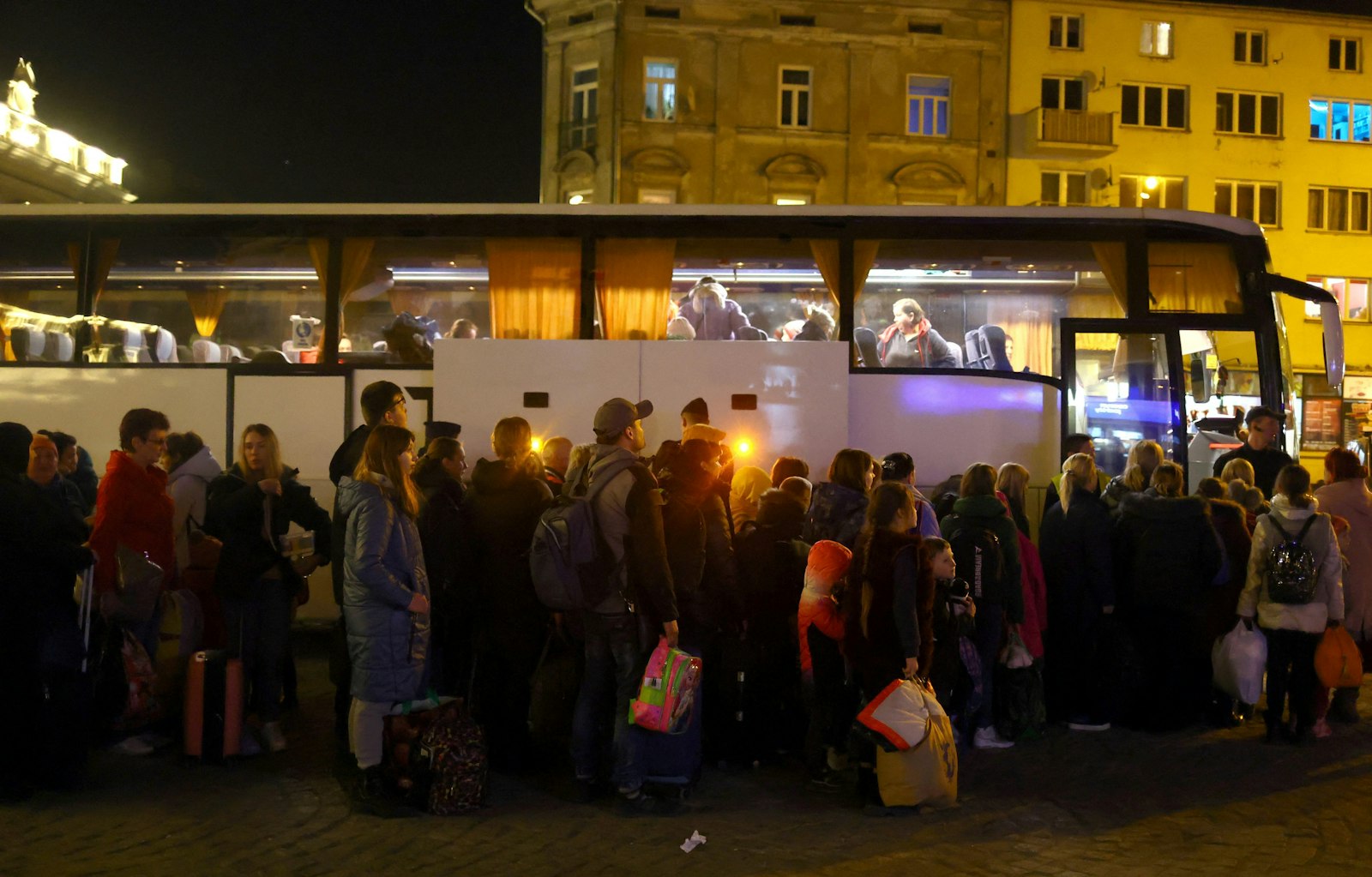 Ukrainian refugees in Przemysl, Poland, wait to board a bus to take them to a temporary shelter March 23, 2022, after fleeing the Russian invasion. (CNS photo/Hannah McKay, Reuters)