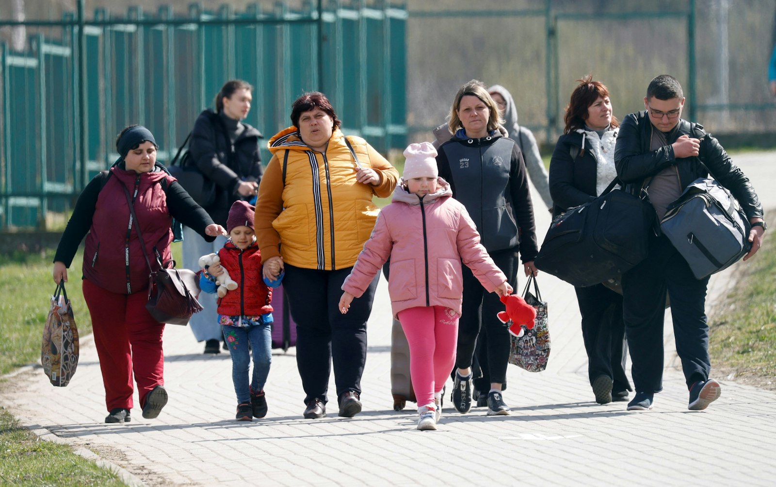 Refugiados ucranianos caminan después de cruzar la frontera entre Ucrania y Polonia en Medyka, Polonia, el 12 de abril de 2022, tras huir de la guerra rusa. En Polonia, la comunidad ecuménica de El Arca en Wroclaw, está ayudando a los refugiados ucranianos, incluidos los que tienen discapacidades de desarrollo. (CNS photo/Leonhard Foeger, Reuters)