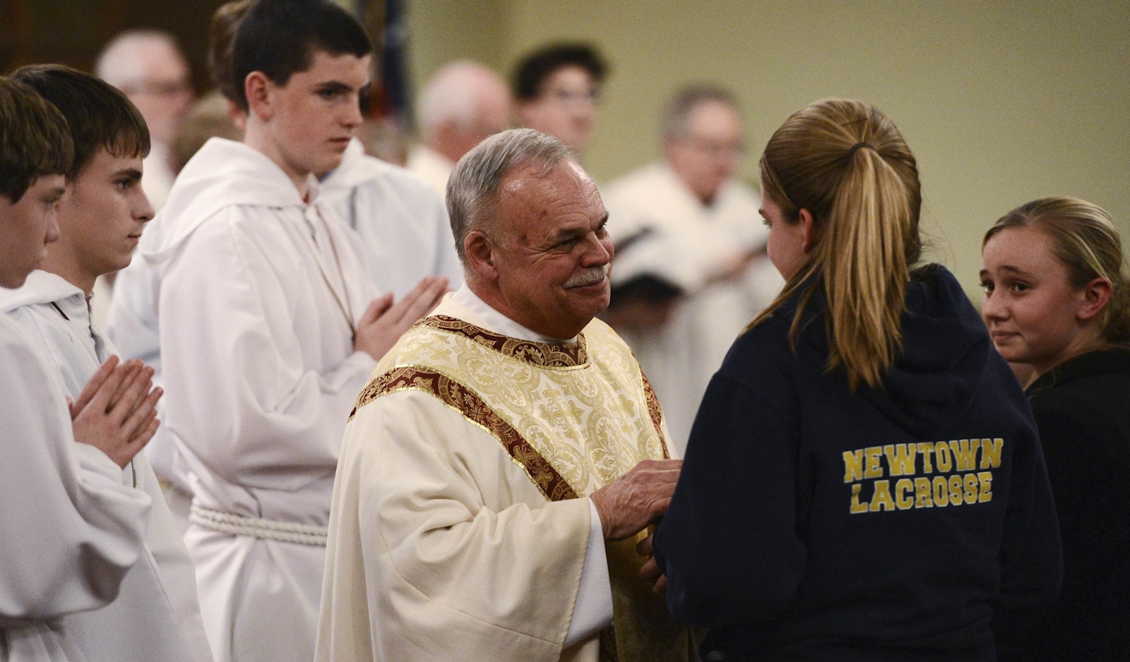 Msgr. Robert Weiss speaks to young women inside St. Rose of Lima Church during a vigil service Dec. 14, 2012, in Newtown, Conn. At least eight of the 20 children killed in the shooting rampage at nearby Sandy Hook Elementary were from St. Rose, a parish of 3,200 families and the only Catholic church in Newtown. (CNS photo/Andrew Gombert, pool via Reuters)