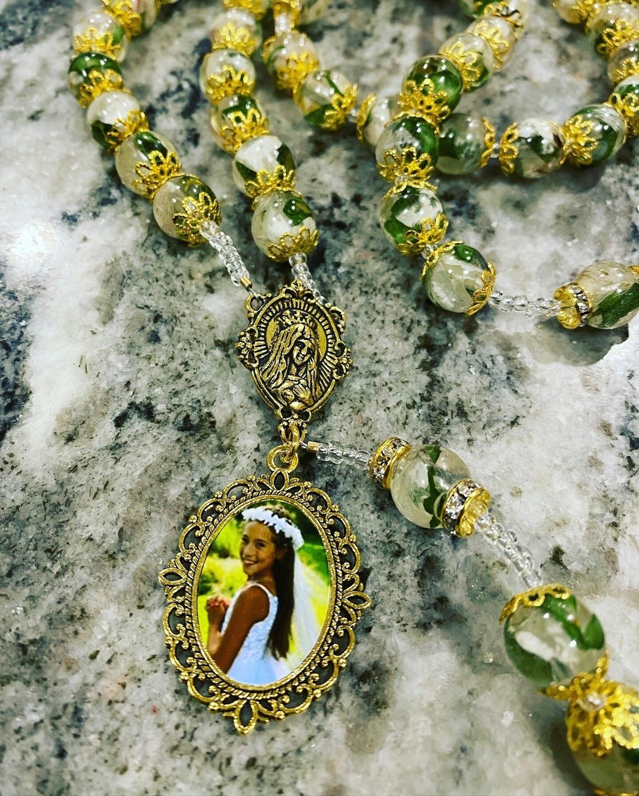 A rosary Joseph designed that was made from the centerpieces of a young girl's first Communion celebration. Her mother asked Joseph to add a photo pendant of her in her Communion gown.