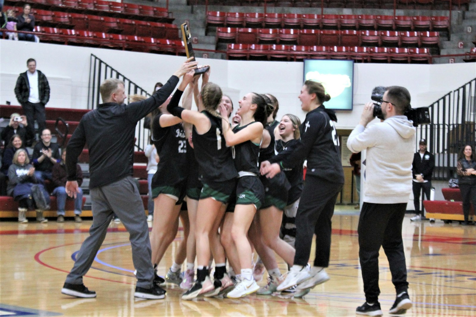 Fr. Gabriel Richard players celebrate after coach Tim Cain presents them with the Catholic League Bishop Division championship trophy.