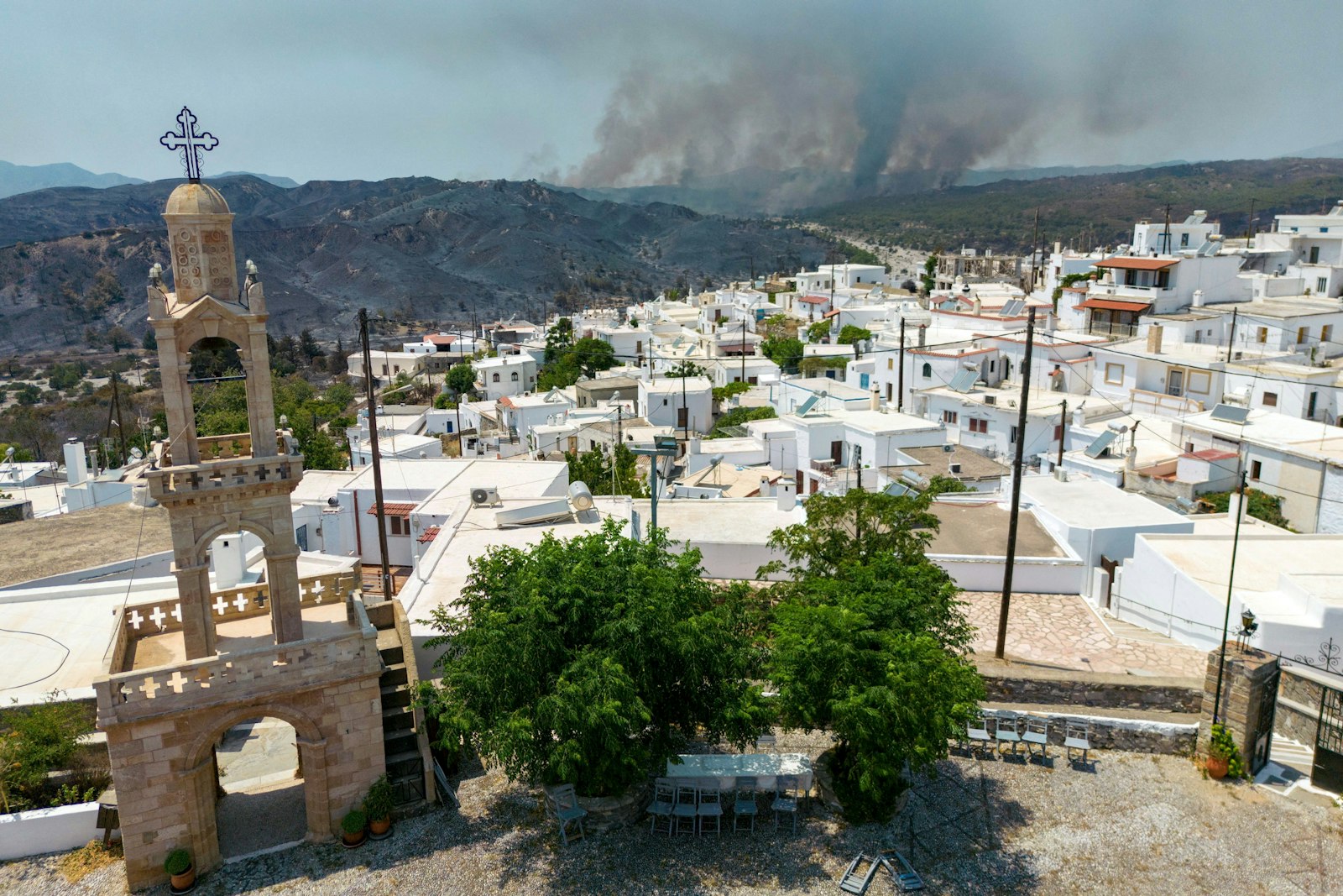 The grounds of the Church of Virgin Mary are seen in village of Asklipieio, as a wildfire burns in the background on the island of Rhodes, Greece, July 26, 2023. Catholics in Greece have called for lessons to be learned after a wave of fires devastated parts of the country amid highest summer temperatures for half a century. (OSV News photo/Nicolas Economou, Reuters)