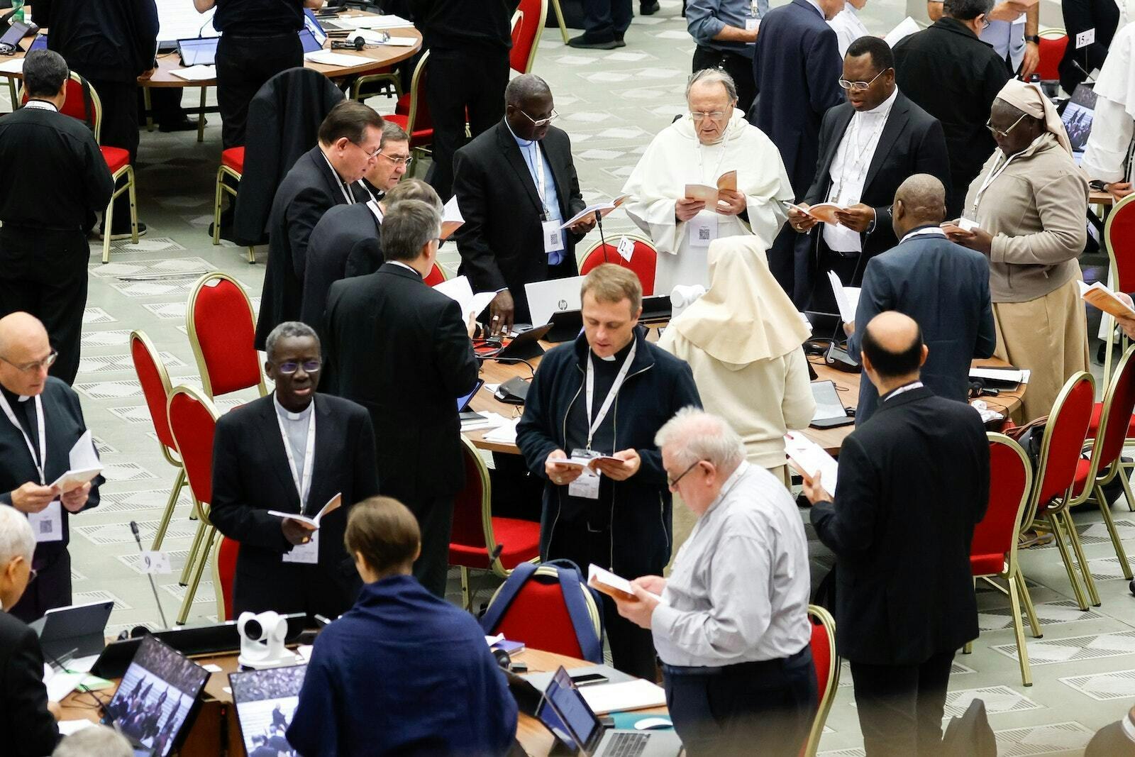 Members of the assembly of the Synod of Bishops pray before a working session in the Vatican's Paul VI Audience Hall Oct. 26, 2023. (CNS photo/Lola Gomez)