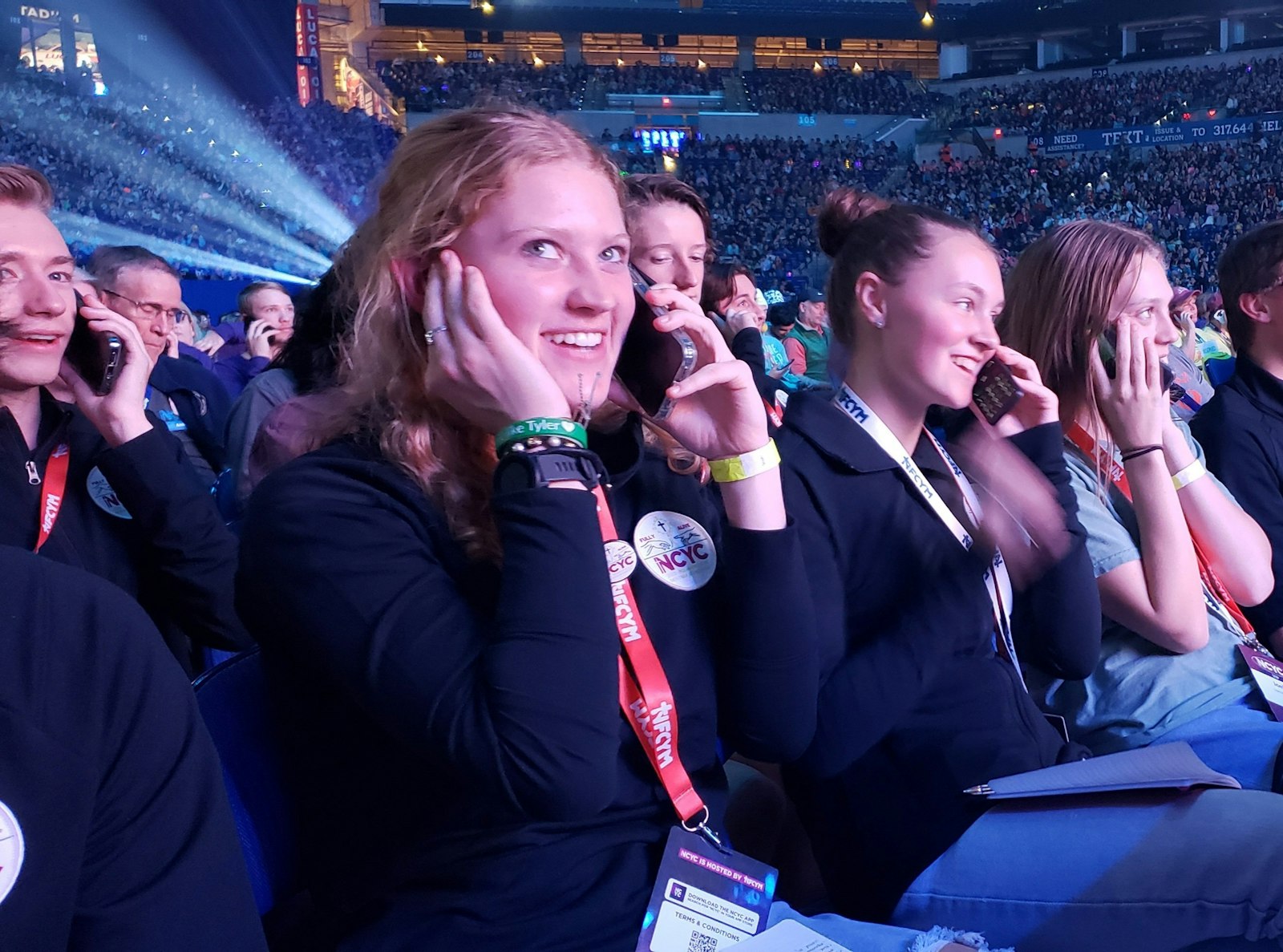 Grace Stecker of the Diocese of Helena, Mont., and those around her call a loved one (for Grace, her dad), as an exercise during the opening session of the National Catholic Youth Conference in Lucas Oil Stadium in Indianapolis on Nov. 16. (OSV News photo/Natalie Hoefer, The Criterion)