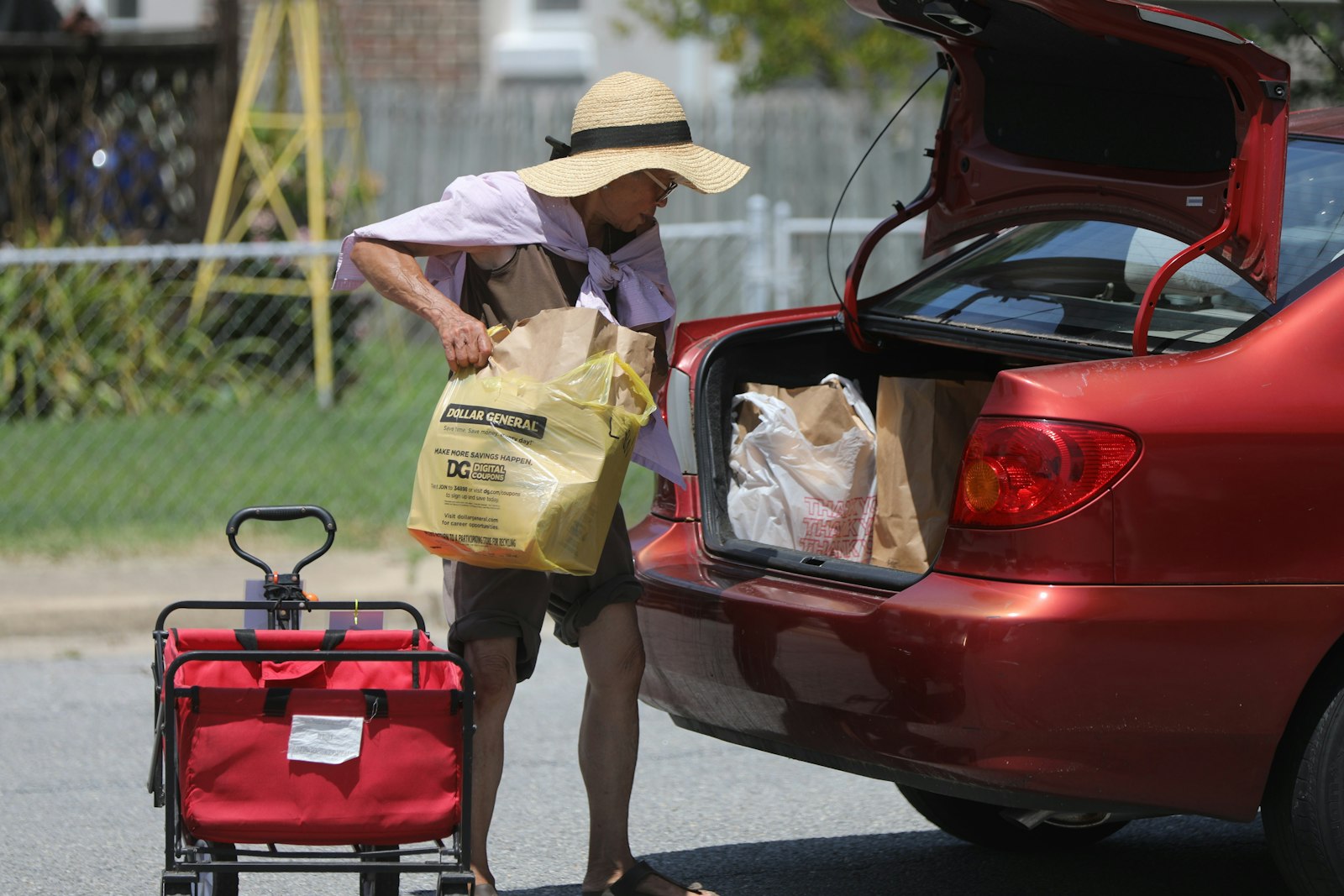 A volunteer with the Ladies of Charity of Calvert County, Md., loads bags of food and other provisions into the car of a person in need at a food pantry July 13, 2021, held on the grounds of St. Anthony's Catholic Church in North Beach. Thirty years ago, in November 1993, the U.S. bishops approved the statement "Communities of Salt and Light: Reflections on the Social Mission of the Parish," which continues to serve as a roadmap for parish social ministry. (OSV News photo/Bob Roller)