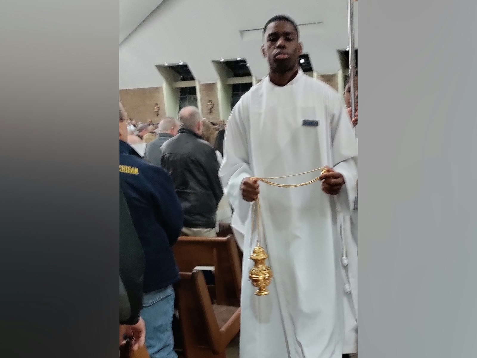 Nnaemeka Ikechi leads the Holy Thursday procession at St. Kieran Parish in Shelby Township, where he’s been an altar server since the sixth grade. (Don Horkey | Special to  Detroit Catholic)