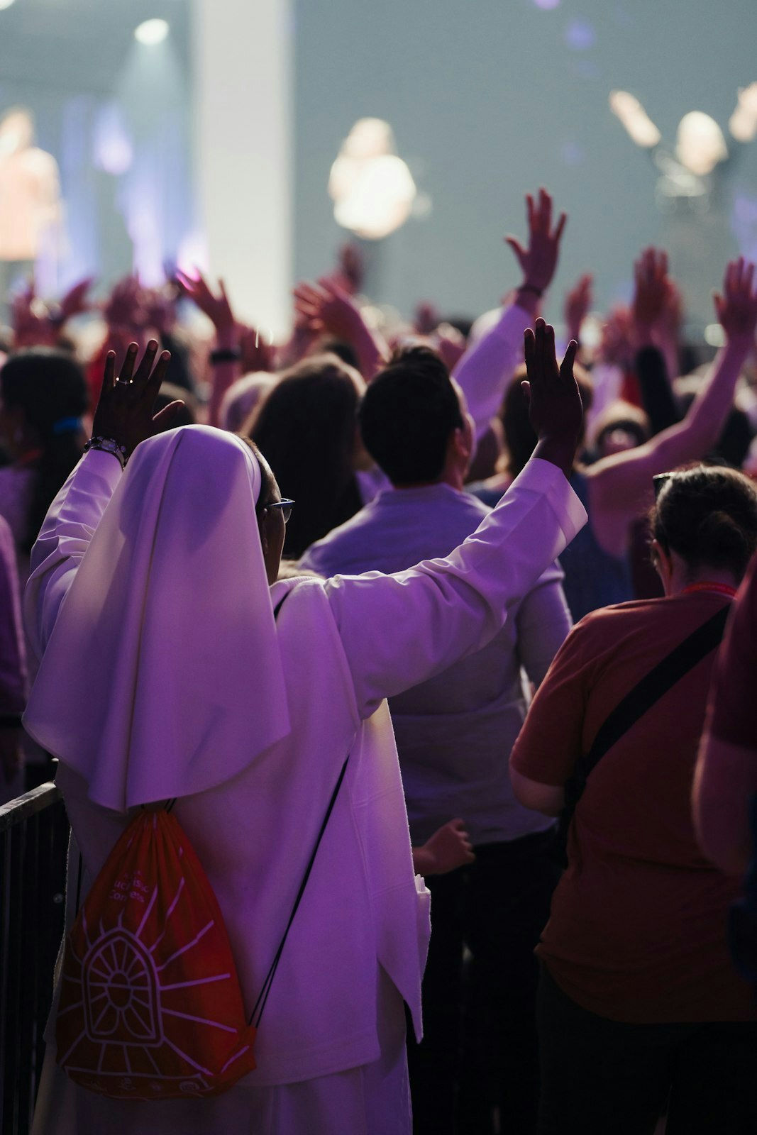 Religiosos, laicos y clérigos levantan sus manos en señal de alabanza durante una sesión musical de adoración en el Congreso Eucarístico Nacional de Indianápolis.