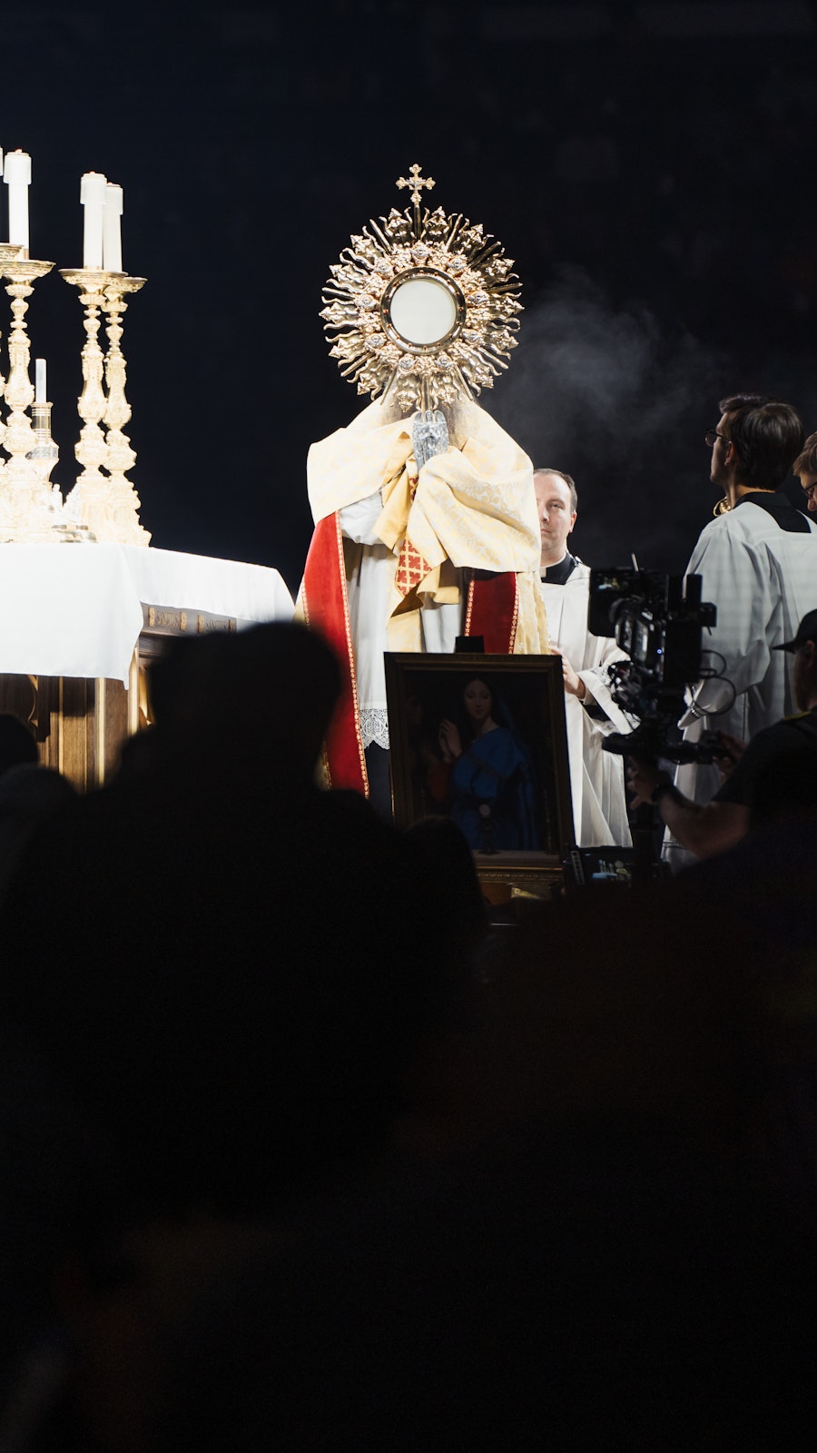 A priest holds the monstrance with the Blessed Sacrament during Eucharistic adoration at the National Eucharistic Congress at Lucas Oil Stadium in Indianapolis.