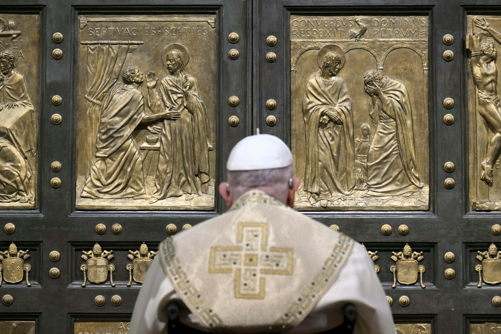 Pope Francis pauses in prayer before knocking on the Holy Door of St. Peter's Basilica at the Vatican Dec. 24, 2024, to open it and inaugurate the Holy Year 2025. (CNS photo/screen grab, Vatican Media)