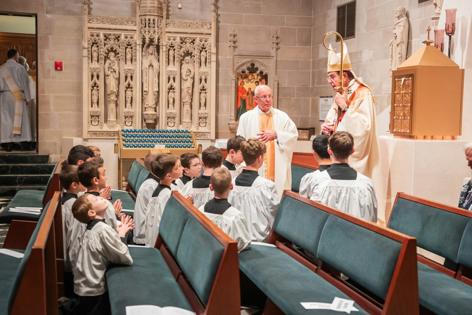 Archbishop Vigneron talks with altar servers in the Eucharistic chapel of the Cathedral of the Most Blessed Sacrament in Detroit during the Chrism Mass.