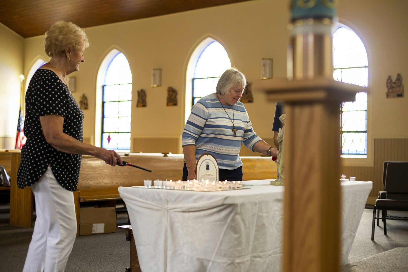 Women light candles at St. Mary Mystical Rose Parish in Armada in August 2021. The parish opened its doors to visitors during the Armada Fair, allowing people to come inside, light a candle, and pray. (Valaurian Waller | Detroit Catholic)