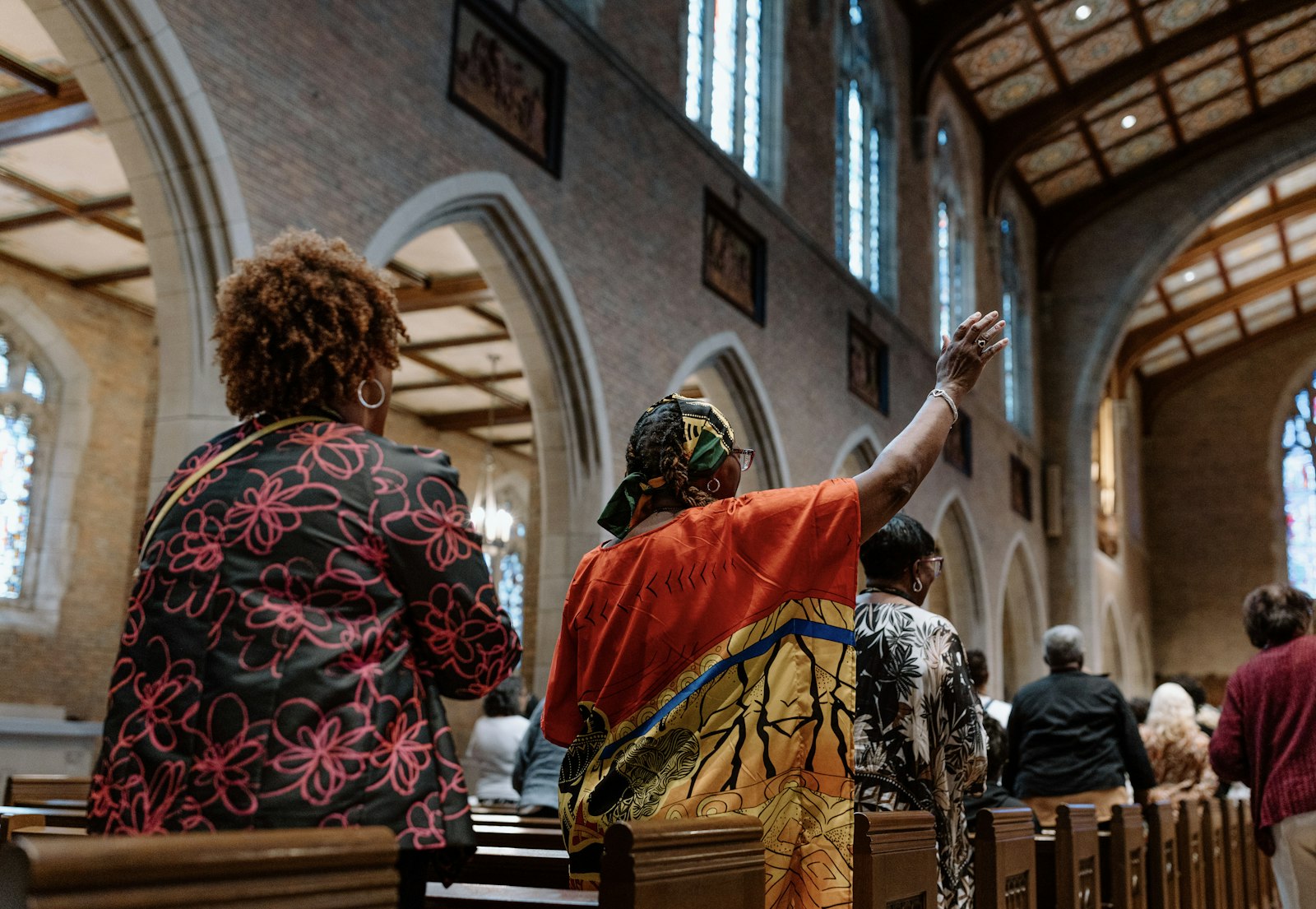 During Mass in the Chapel of the Sacred Heart, believers raise their hands to sing.