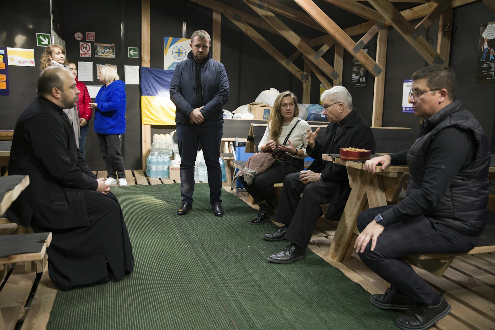 Bishop Monforton, second right, speaks with clergy and aid workers inside a makeshift shelter in Kiev, Ukraine, during a personal visit of solidarity to the Eastern European nation a year and a half after the war began.