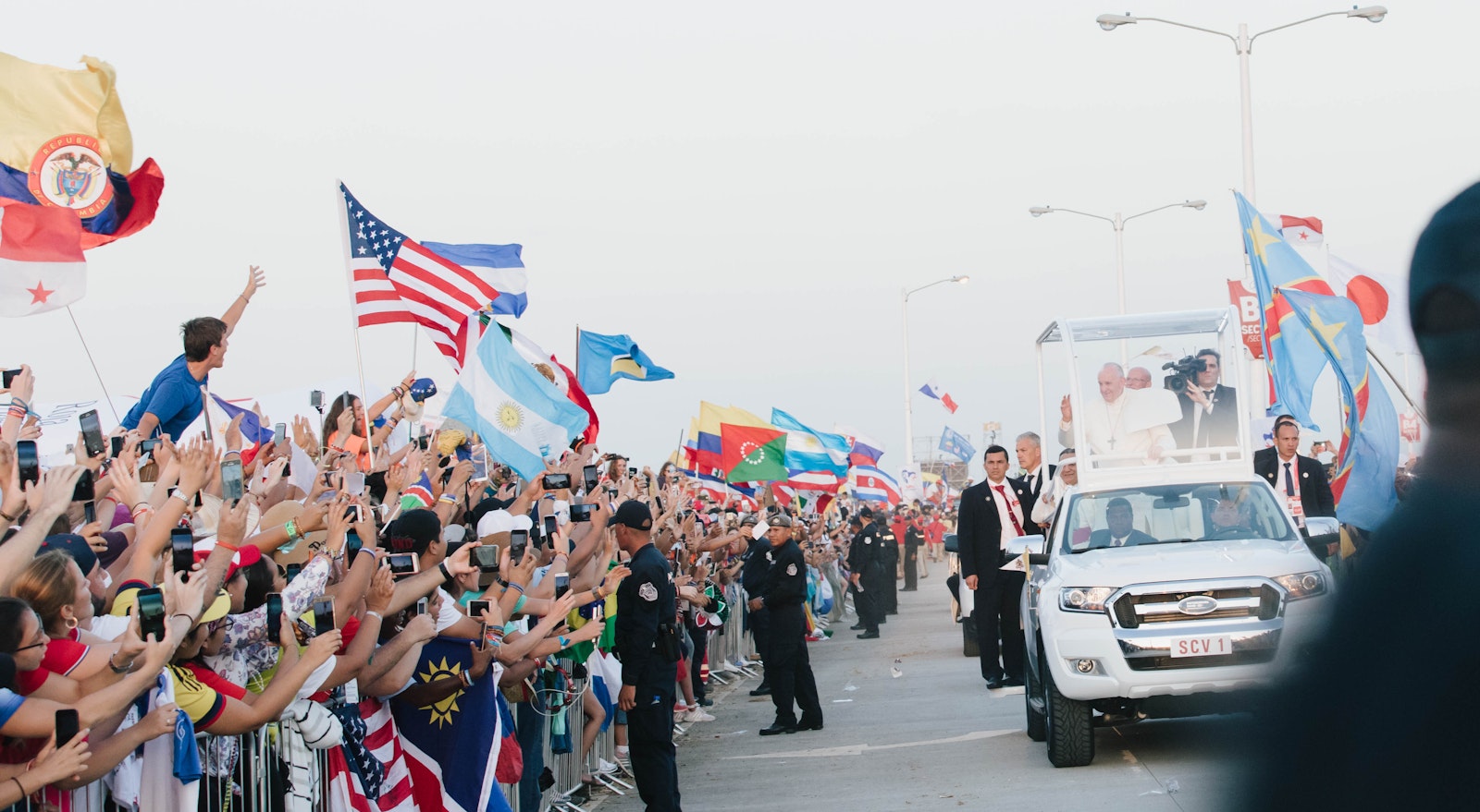 Pilgrims wave flags and cheer as Pope Francis rides by in the popemobile during World Youth Day in Panama City, Panama, in 2019.