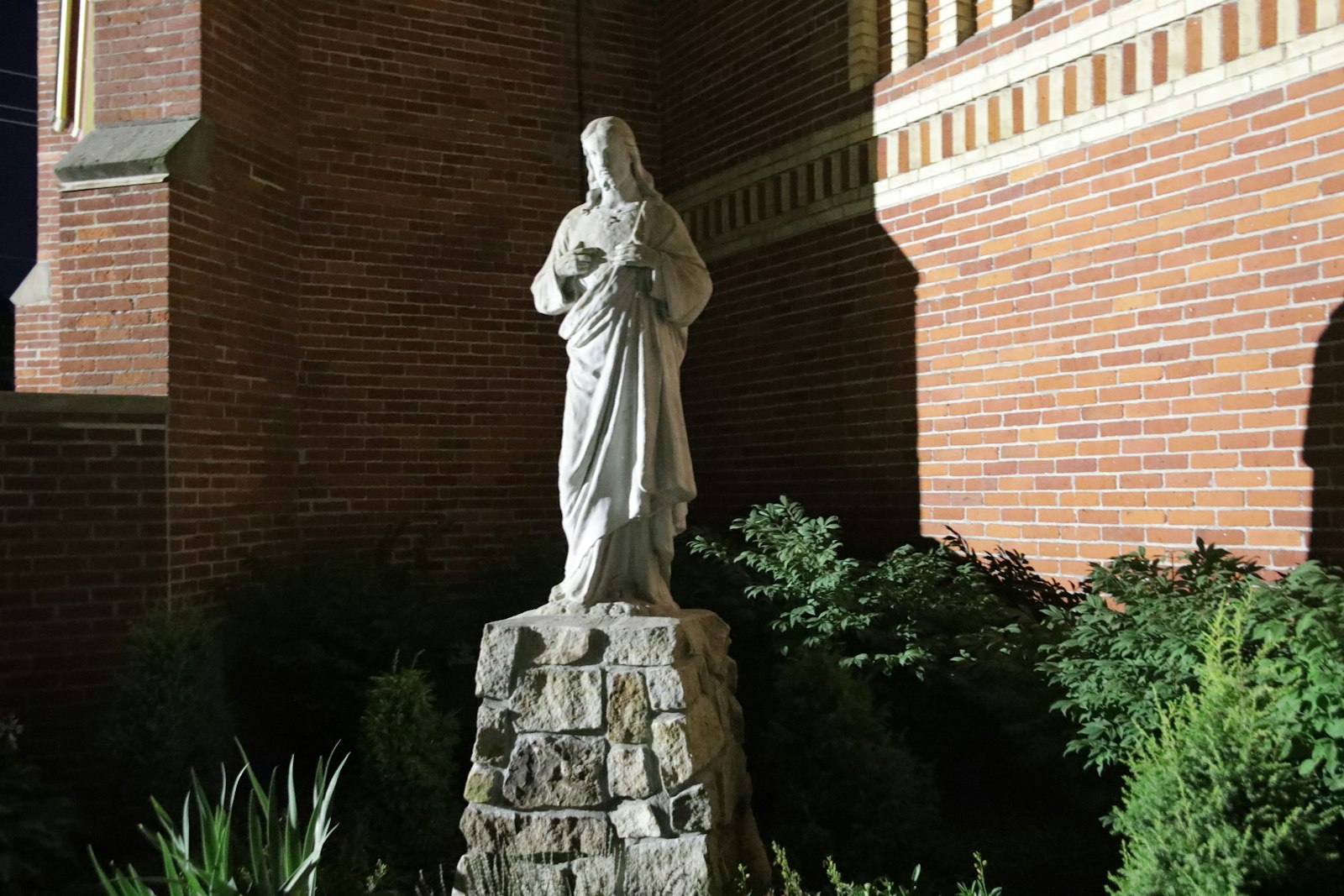 Una estatua de Jesús aparece en la oscuridad del campus de San Carlos Borromeo en Newport.