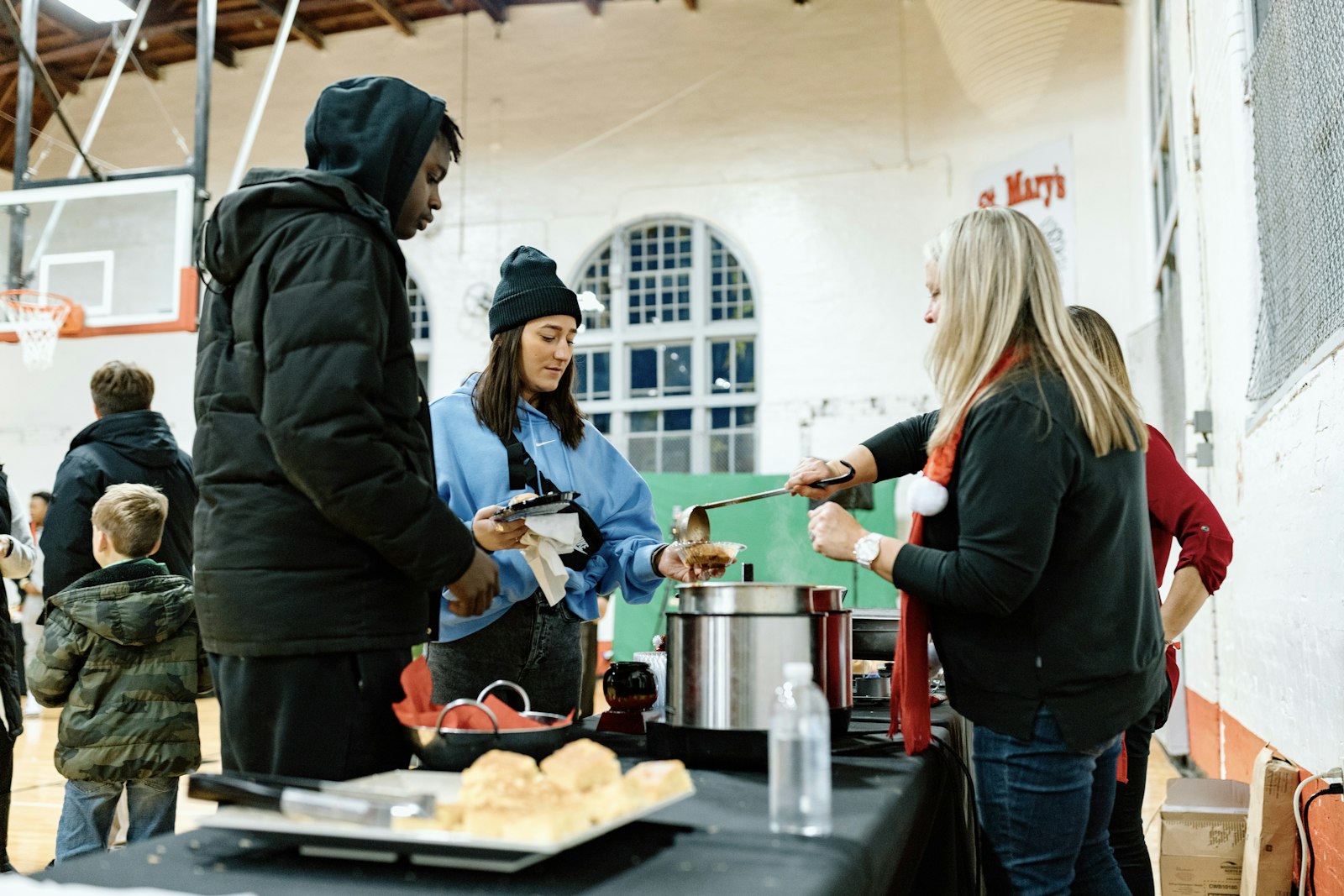 Volunteers serve hot meals, beverages and Christmas cheer inside the school's gymnasium. (Alissa Tuttle | Special to Detroit Catholic)