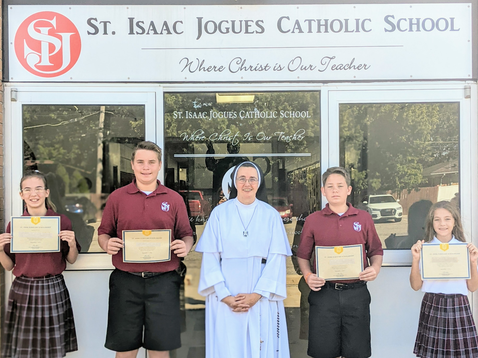Scholarship recipients from St. Isaac Jogues Catholic School in St. Clair Shores hold up their certificates.