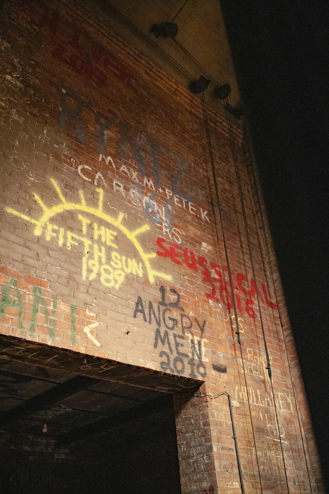 Graffiti on the wall behind the stage includes dates of previous performances, a living relic to Sacred Heart's rich theatrical past.