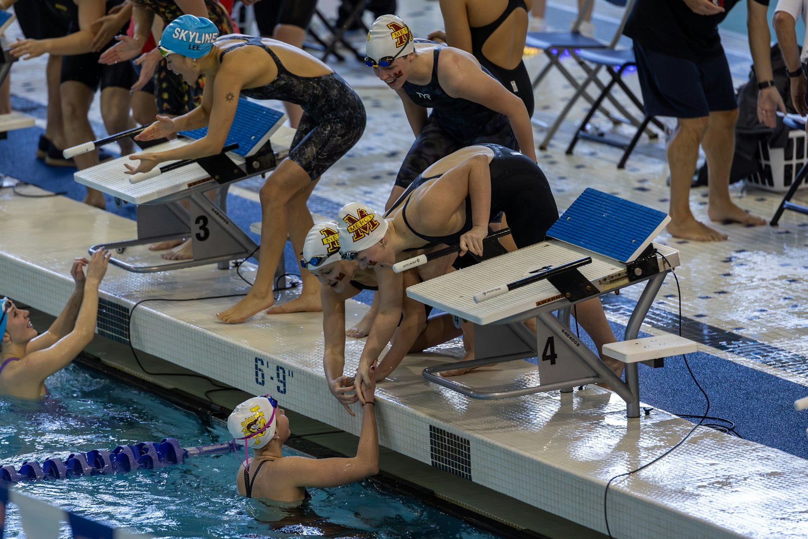 Mackenzie Conway, Campbell Shore and Leah Graves congratulate anchor swimmer Avery Tack after Farmington Hills Mercy won the state championship in the 200-yard freestyle relay. The Marlins also won the overall team title for the first time since 2019.