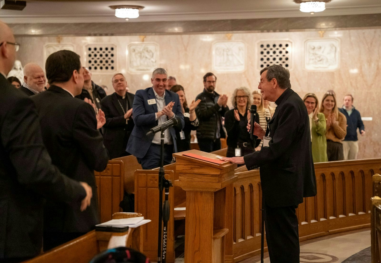 Miembros de la curia arquidiocesana aplauden al Arzobispo saliente de Detroit, Allen H. Vigneron, después de que se dirigiera al personal tras la oración de la mañana en la St. Aloysius Church en Detroit el 12 de febrero. Hasta la instalación del Arzobispo designado Edward J. Weisenburger el 18 de marzo, el Arzobispo Vigneron será el administrador apostólico de la Arquidiócesis de Detroit.