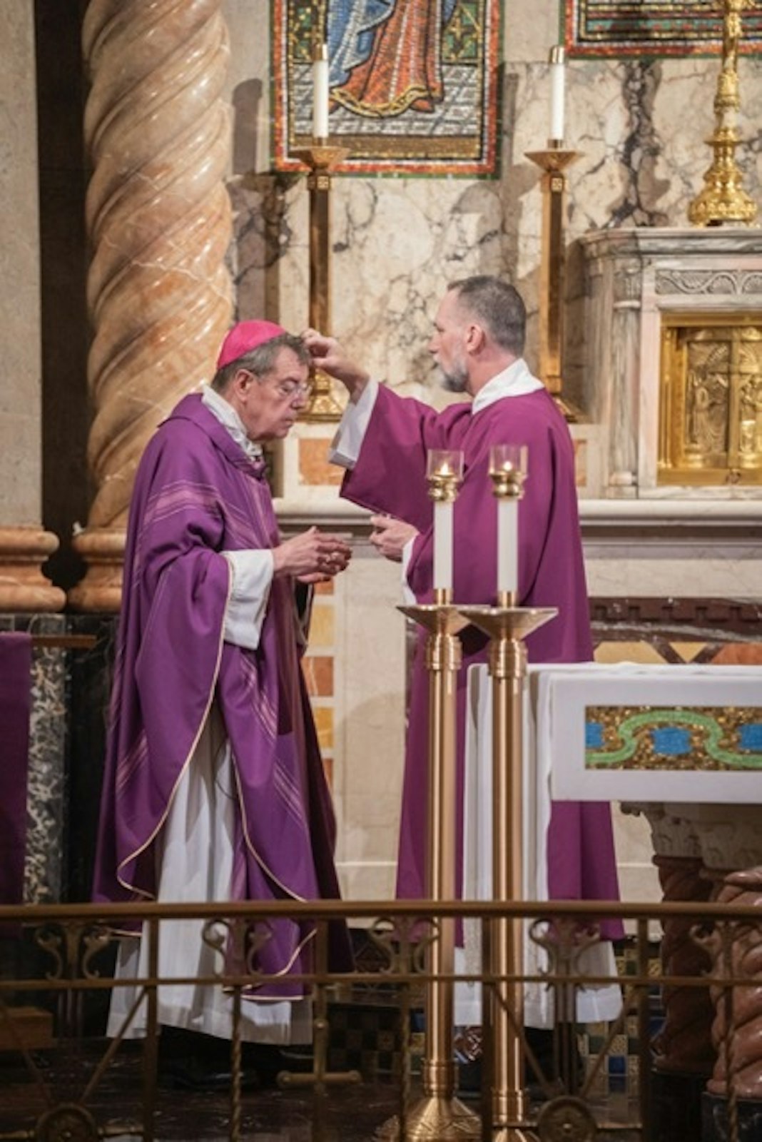 Deacon Christopher Beltowski imposes ashes upon Archbishop Vigneron's forehead.