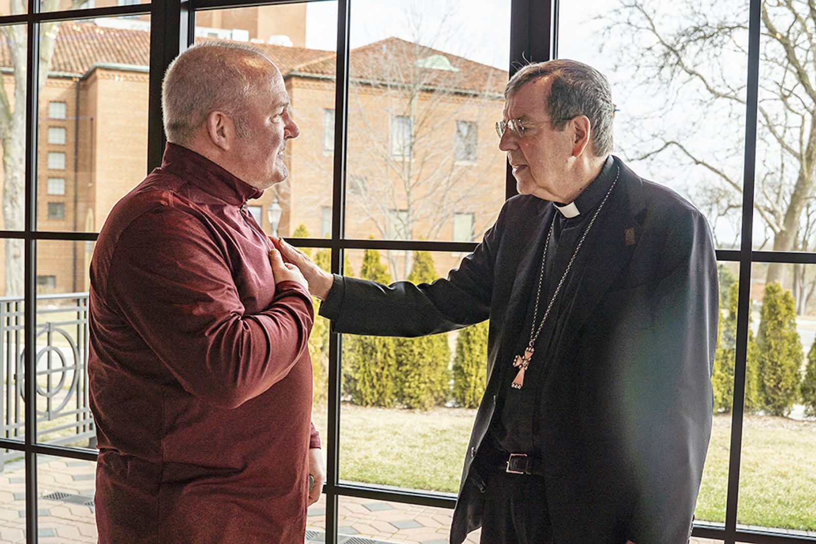 Retiring Archbishop Allen H. Vigneron greets Paul Shapiro, who works in the Department of Human Resources for the Archdiocese of Detroit, in a receiving line at St. John's Resort in Plymouth, where the archbishop gathered for one final time March 12 to thank members of the archdiocesan curia. (Photos by Valaurian Waller | Detroit Catholic)