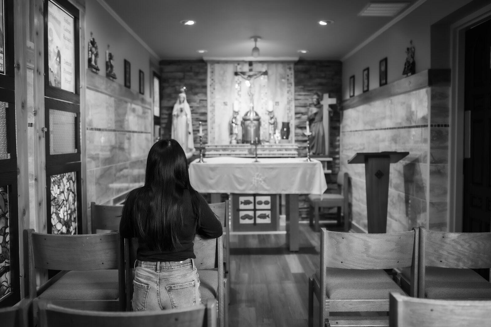 Andreya Vo, a recent convert and college student at the University of Michigan-Dearborn, adores Christ in the Blessed Sacrament in the chapel of the Gabriel Richard Newman Center in Dearborn in this image taken as part of the Archdiocese of Detroit's I AM HERE campaign.