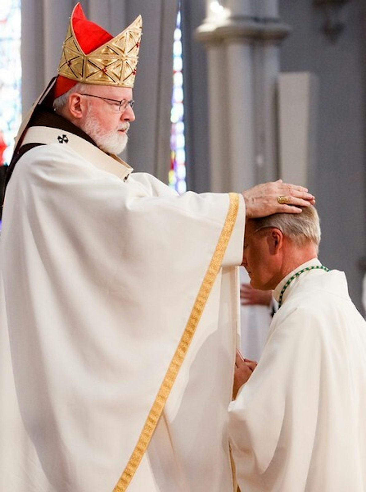 Boston Cardinal Sean P. O'Malley lays his hands upon Archbishop Russell to ordain him to the episcopate at the Cathedral of the Holy Name in Boston on June 3, 2016. (Gregory L. Tracy | The Boston Pilot)