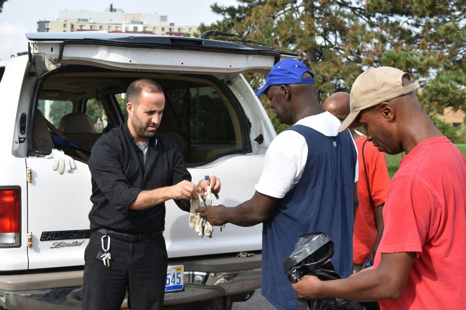 El P. Marko Djonovic reparte herramientas a los participantes de Better Way Detroit en 2018. Al principio, Better Way trabajaba principalmente con hombres que limpiaban parques de la ciudad. (Foto de archivo de Detroit Catholic por Daniel Meloy)