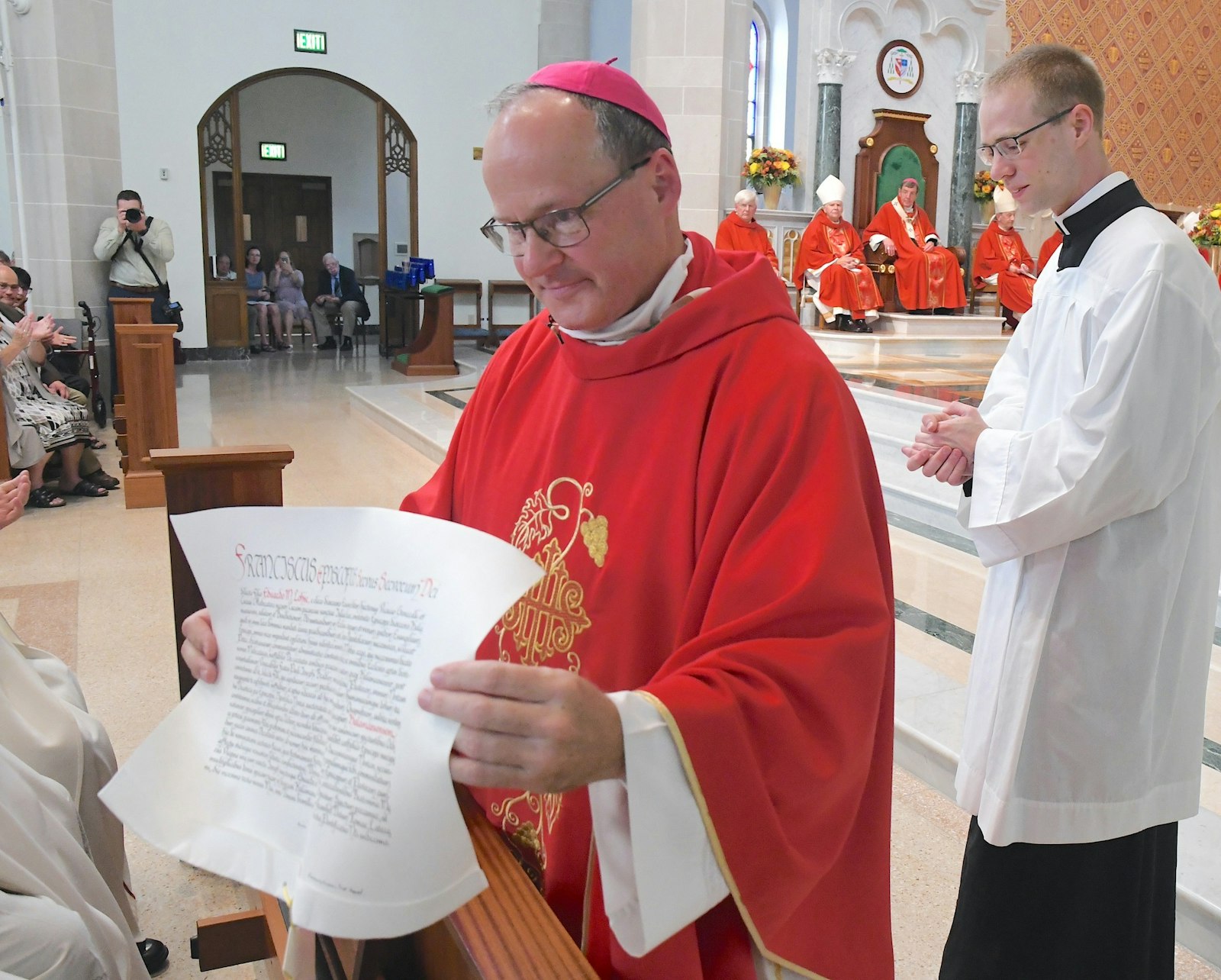 Bishop Lohse shows the faithful the papal decree announcing his appointment as Kalamazoo's bishop.  (John Grap | Diocese of Kalamazoo)