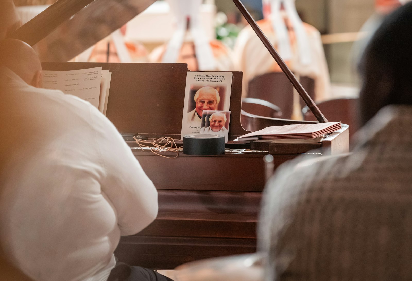 A prayer card and funeral program for Bishop Thomas J. Gumbleton are pictured on a piano in the sanctuary during Bishop Gumbleton's funeral Mass on April 13.