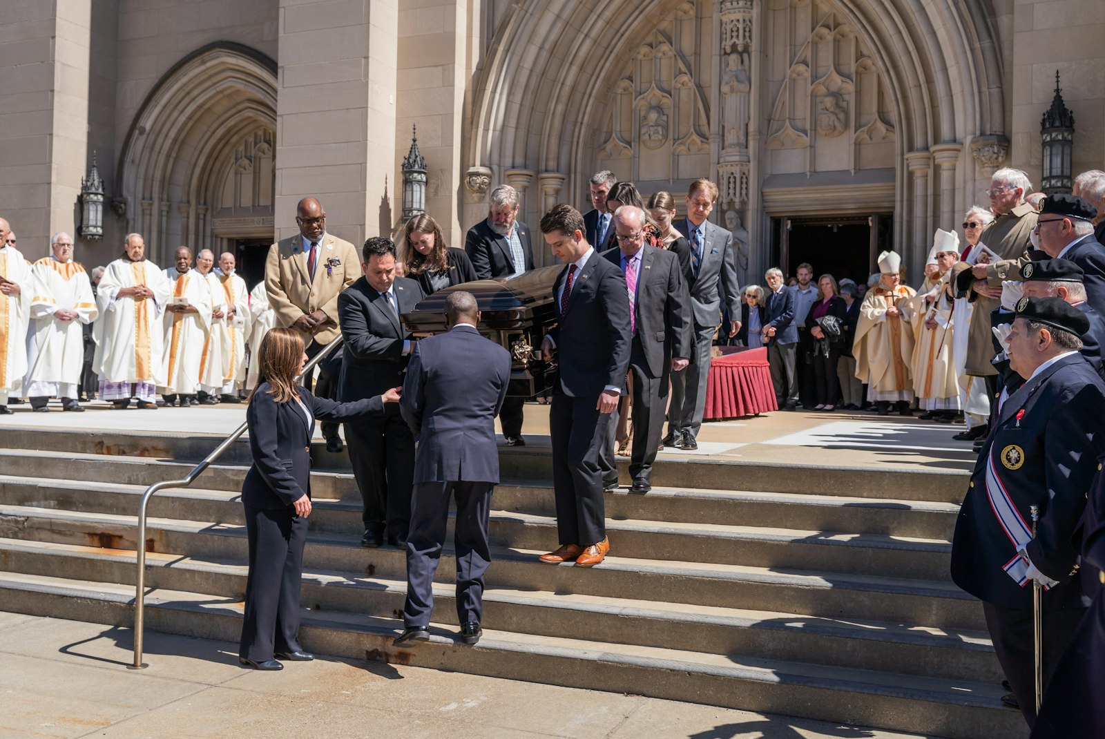 Pallbearers carry Bishop Gumbleton's casket to a waiting hearse following the funeral Mass.