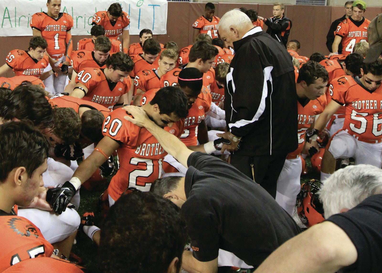 Al Fracassa prays with his Brother Rice football team in the locker room prior to a game. (Photo courtesy of Ken Cendrowski)