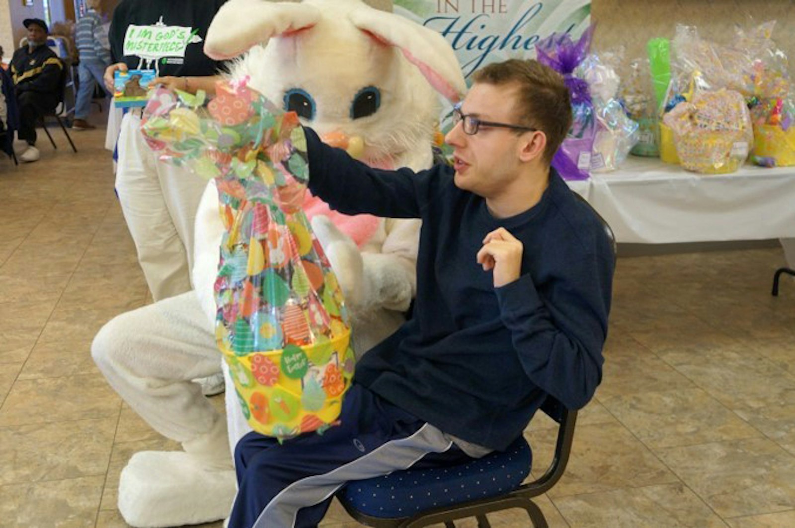 Justin Stephenson recibe una cesta de Pascua de manos del Conejo de Pascua después del programa de servicio de oración el 9 de abril en la Parroquia de Cristo Nuestra Luz en Troy.