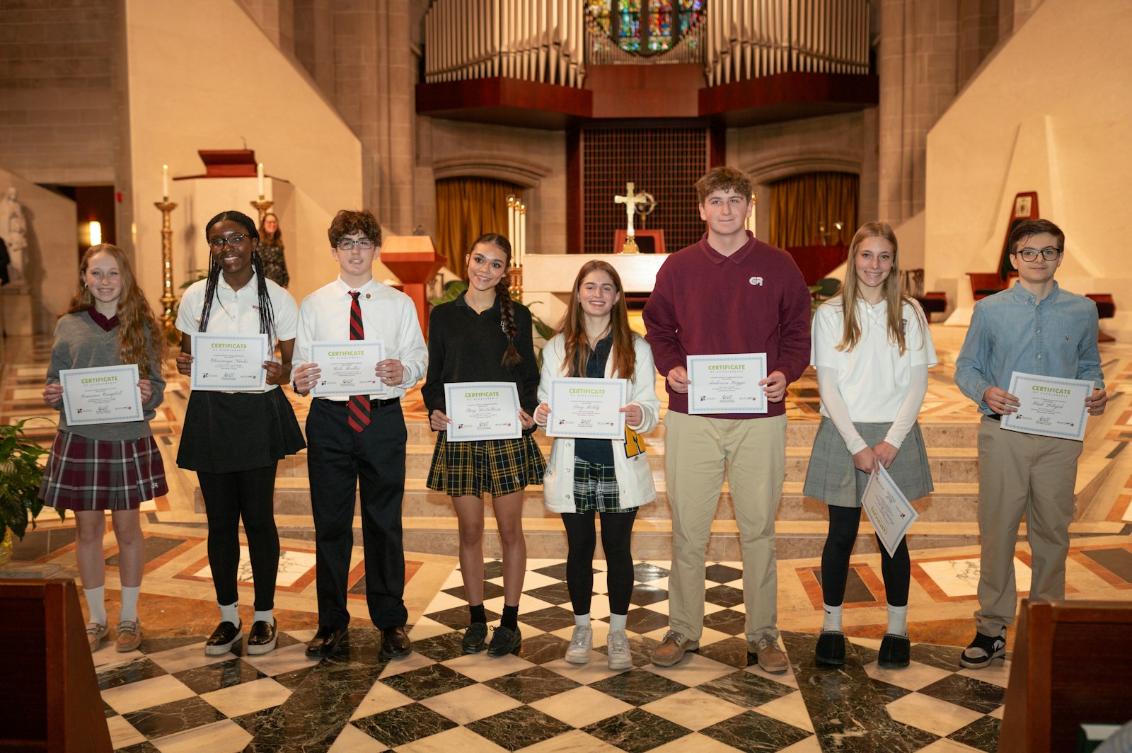 Finalists in Alliance Catholic Credit Union's eighth annual "Live it. Show it. Share it." Scholarship Contest hold up their certificates during an award presentation following the Catholic Schools Week Mass at the Cathedral of the Most Blessed Sacrament.
