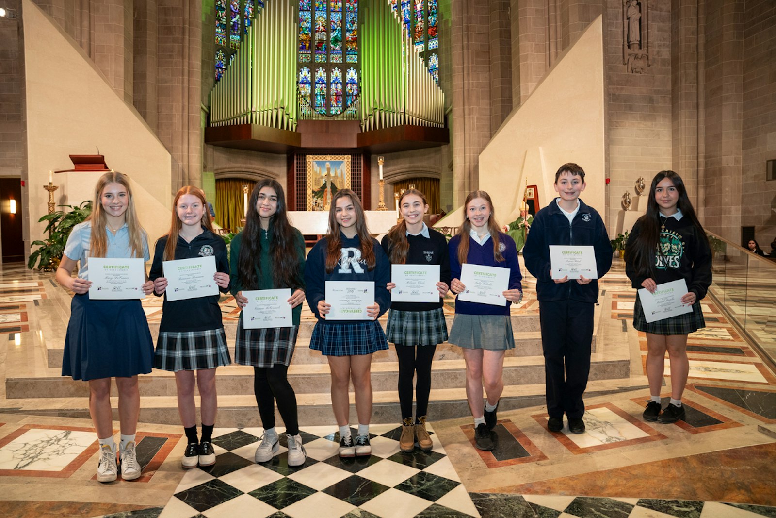 Winners of the ninth annual Alliance Catholic Credit Union "Live it. Show it. Share it" scholarship competition pose with their award certificates, given to them after the Catholic Schools Week Mass.