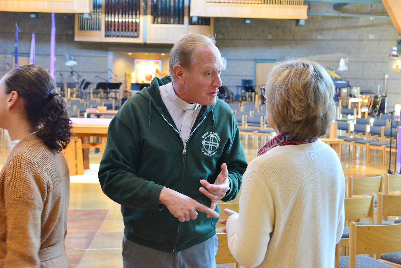 Fr. Bill Promesso talks with Christ the Redeemer worship coordinator Mari Reyes inside the church. Shortly after the Nov. 19 explosion, Christ the Redeemer staff members sprang into action, opening the church and providing hospitality, a warm place to gather, and for at least two Keatington residents, a place to sleep for the night.