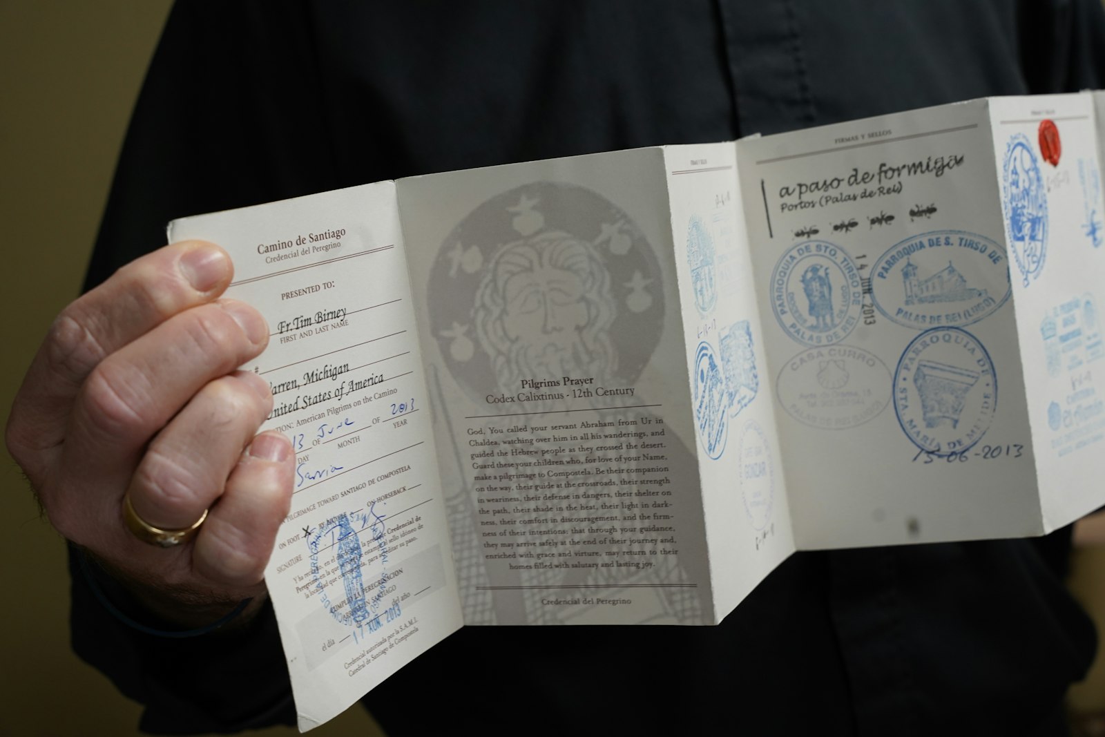 Fr. Birney holds up a passport of a previously completed El Camino pilgrimage, marked with stamps from the various restaurants, hostels, and churches where the discernment group he was leading celebrated Mass. (Daniel Meloy | Detroit Catholic)