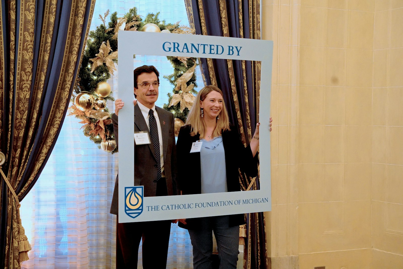Deacon Dominick Pastore and Katie Montes of Mary's Mantle pose for a photograph after receiving a $4,850 grant to support a mentoring program for expectant mothers. Thirty-two Catholic parishes, schools and organizations were awarded grants during the Catholic Foundation of Michigan's award ceremony at the Detroit Athletic Club on Dec. 15.