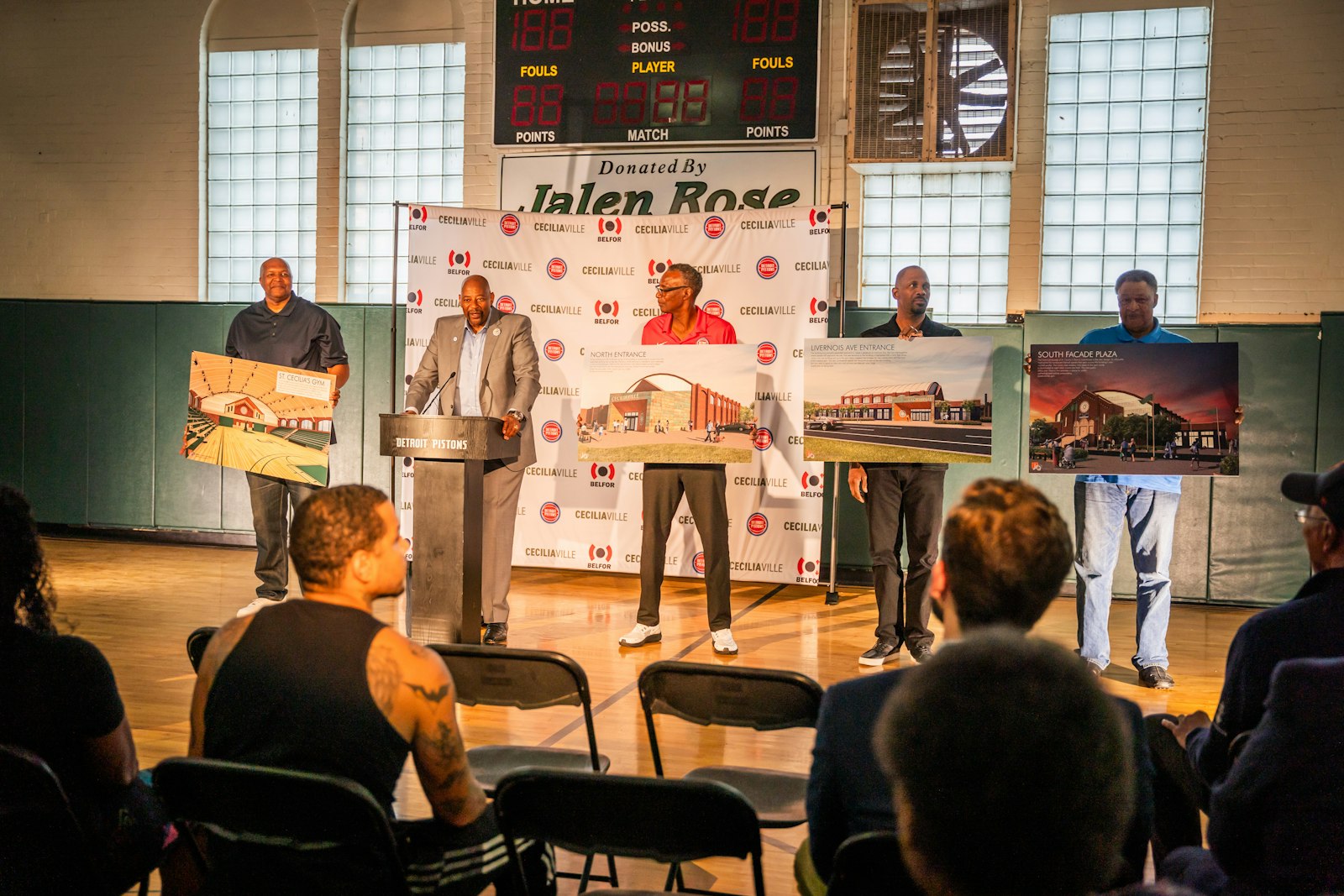 Derrick Coleman, Greg Kelser, Derrick Long and Charlie Edge hold up renderings of what Ceciliaville will look like after renovations while Earl “The Twirl” Cureton speaks at the podium during the Oct. 4, 2023 event.
