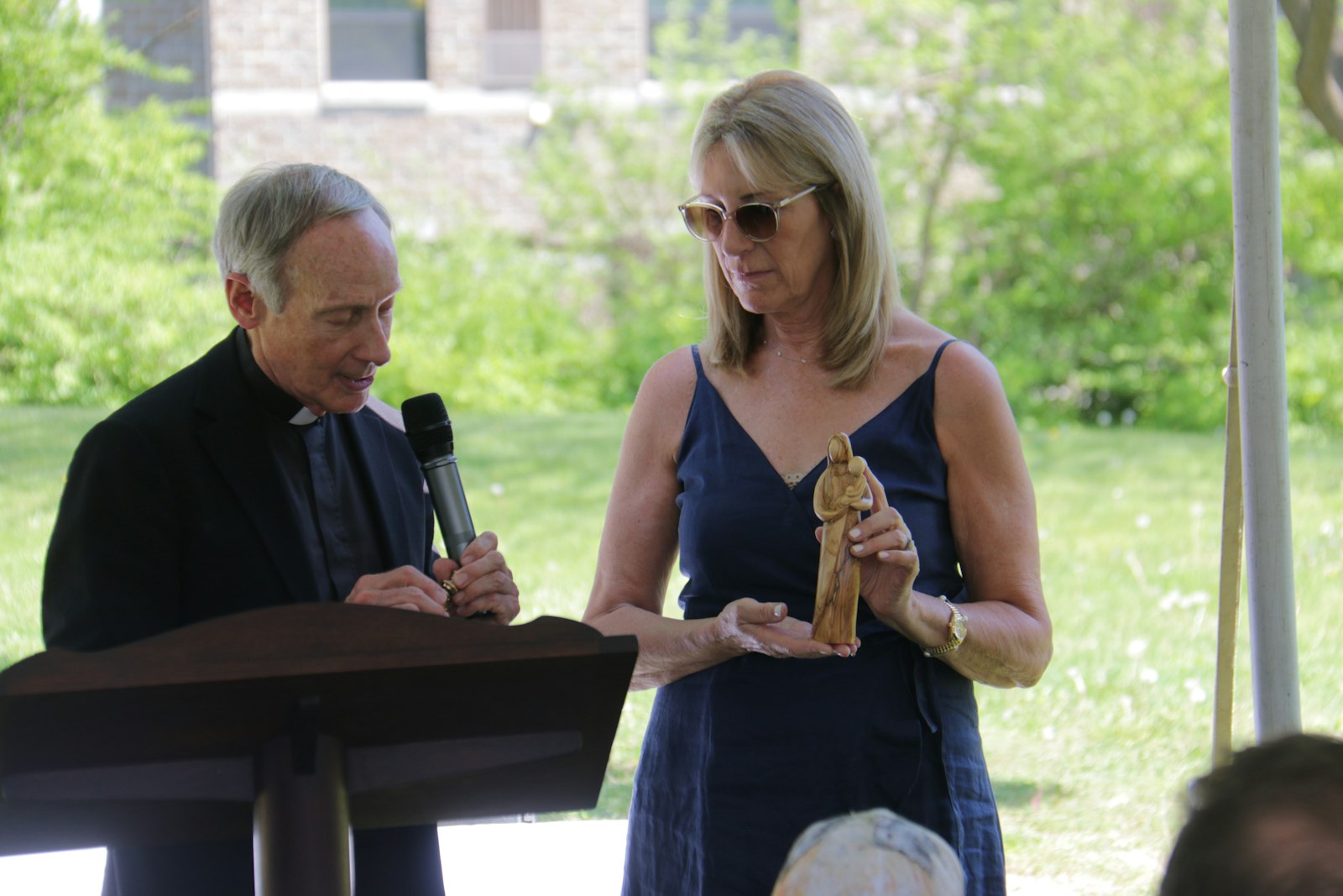 Msgr. John Zenz, chaplain of the Christ Child Society of Detroit, blesses a statue of Mary and the Child Jesus held by Mari MacKenzie of the Christ Child Society on May 15.